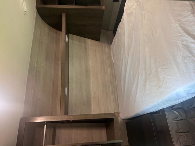 RV rental interior: a clean, white-covered bed and wooden built-in storage optimize space.. Jayco Jay Flight SLX 2021