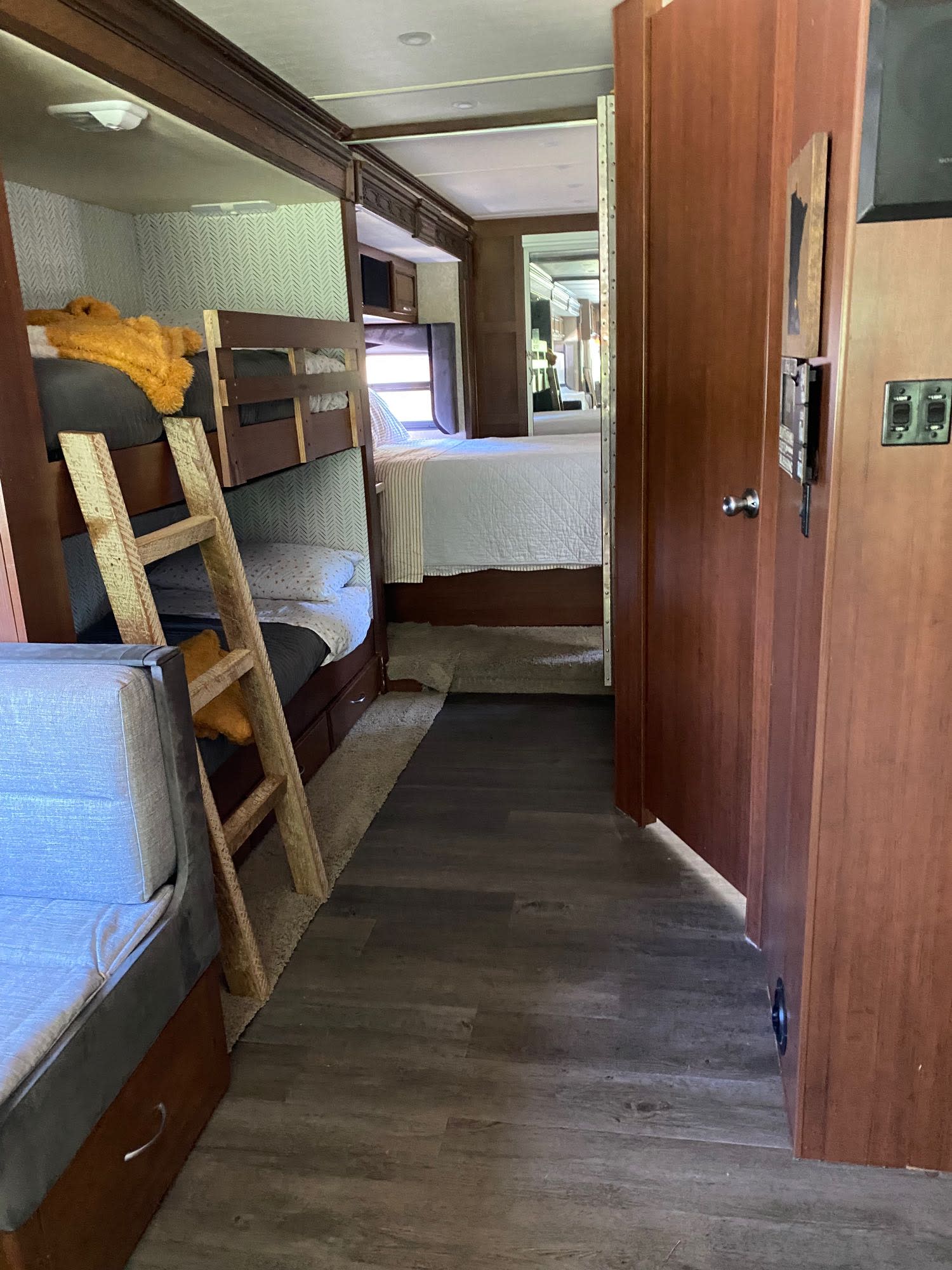 Explore this RV rental's interior: bunk beds, a wooden ladder, & master bedroom through the hall. Ready for your next adventure.. Fleetwood Expedition 38B 2011