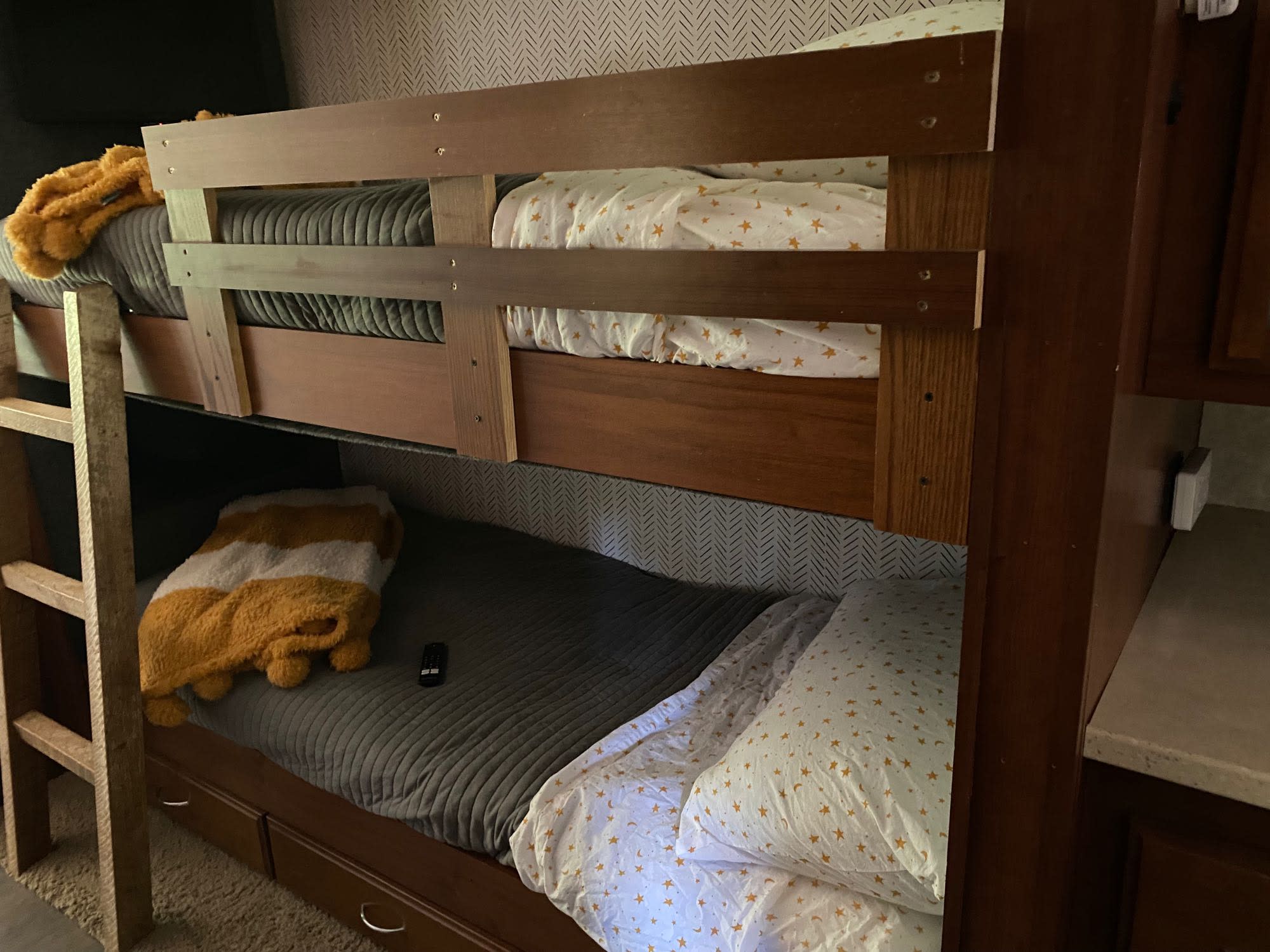 Cozy bunk beds in an RV rental, perfect for family travel. Features quilted mattresses, starry sheets, & under-bed storage.. Fleetwood Expedition 38B 2011