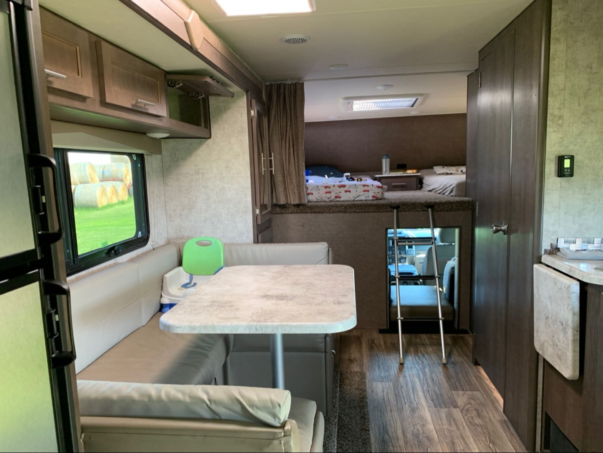 Spacious RV rental interior with a cozy dinette, functional kitchen, and comfortable bunk bed.. Fraserway Adventurer 4 Quad 2017