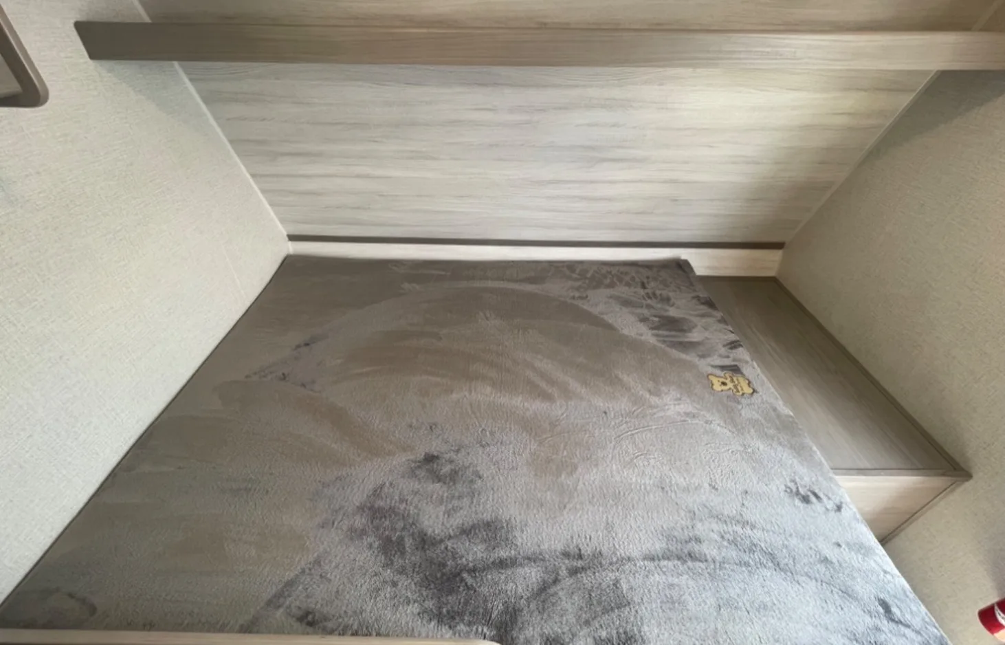 Cozy RV rental bunk bed: a comfortable sleeping area with a soft grey blanket, ideal for your adventures.. Dutchmen Coleman Lantern LT 2023