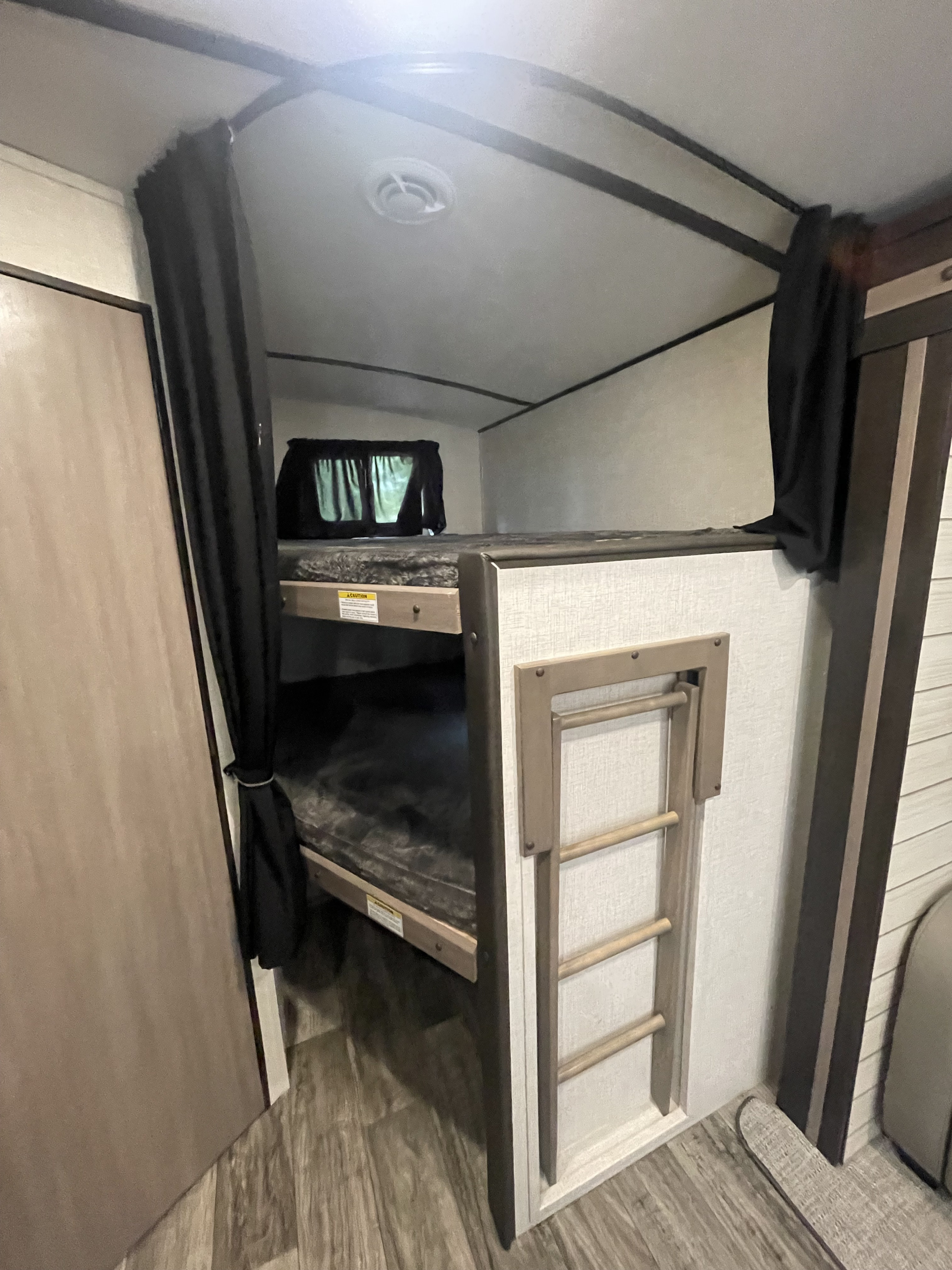 Experience comfort in this RV rental's bunk beds, featuring privacy curtains and a ladder for easy access.. Sunset Trail 272 BH 2022