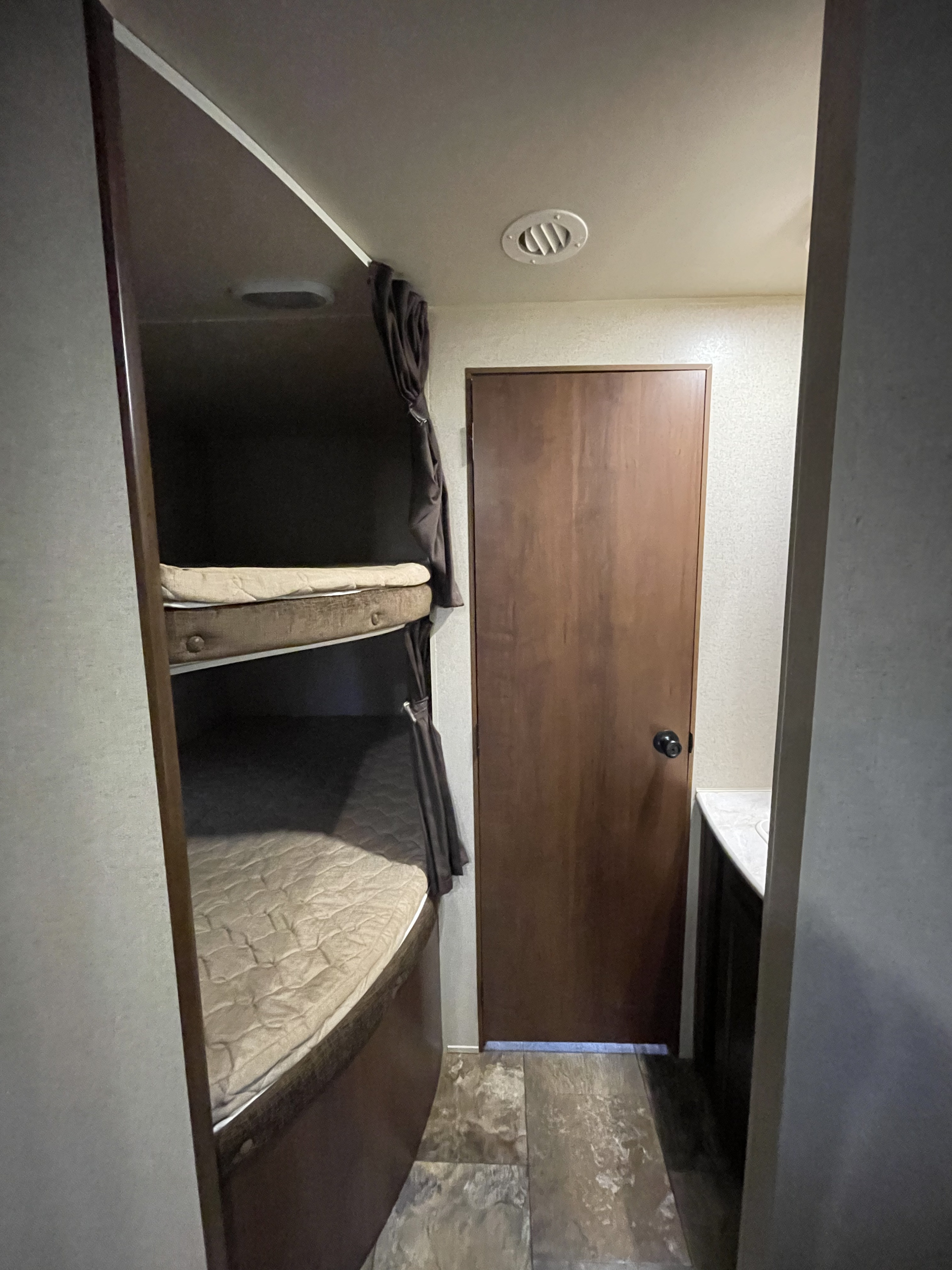 Bunk beds with storage underneath bottom bunk that also leads to outside storage door. Restroom sink across from bunks.. Jayco Jay Flight 2015