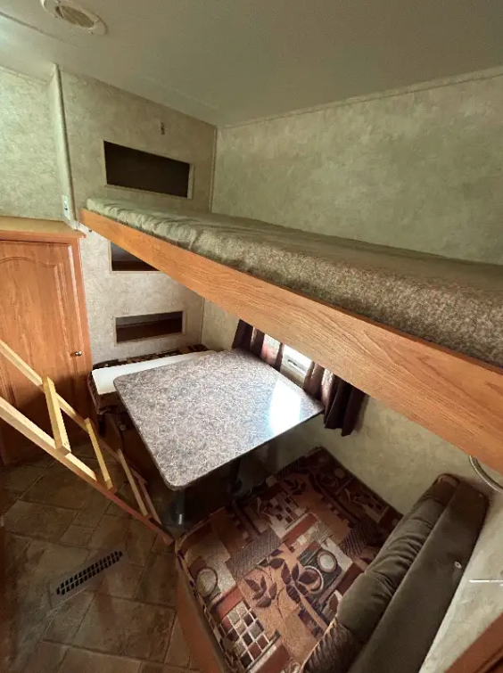 This RV rental offers a cozy bunk bed above a convertible dinette with storage, ideal for families.. Forest River Surveyor 2009