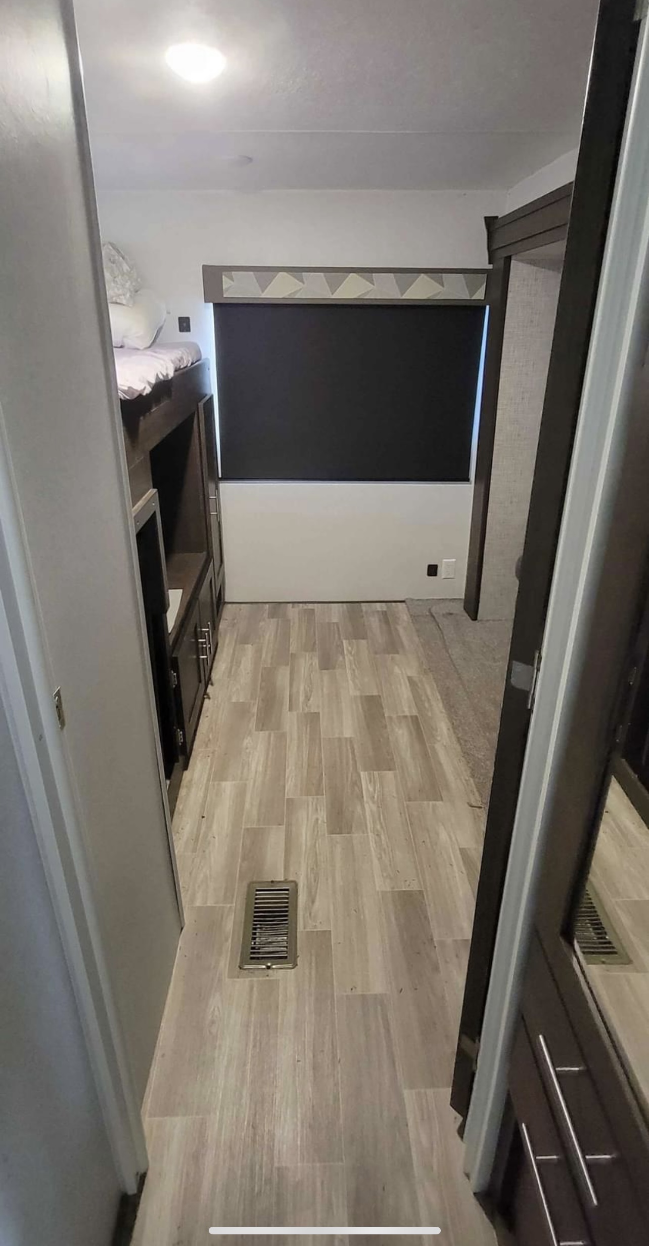 RV rental bunk room: light wood-look flooring, built-in bunk beds, and a window with a blackout shade. Compact interior.. Forest River Salem 2019