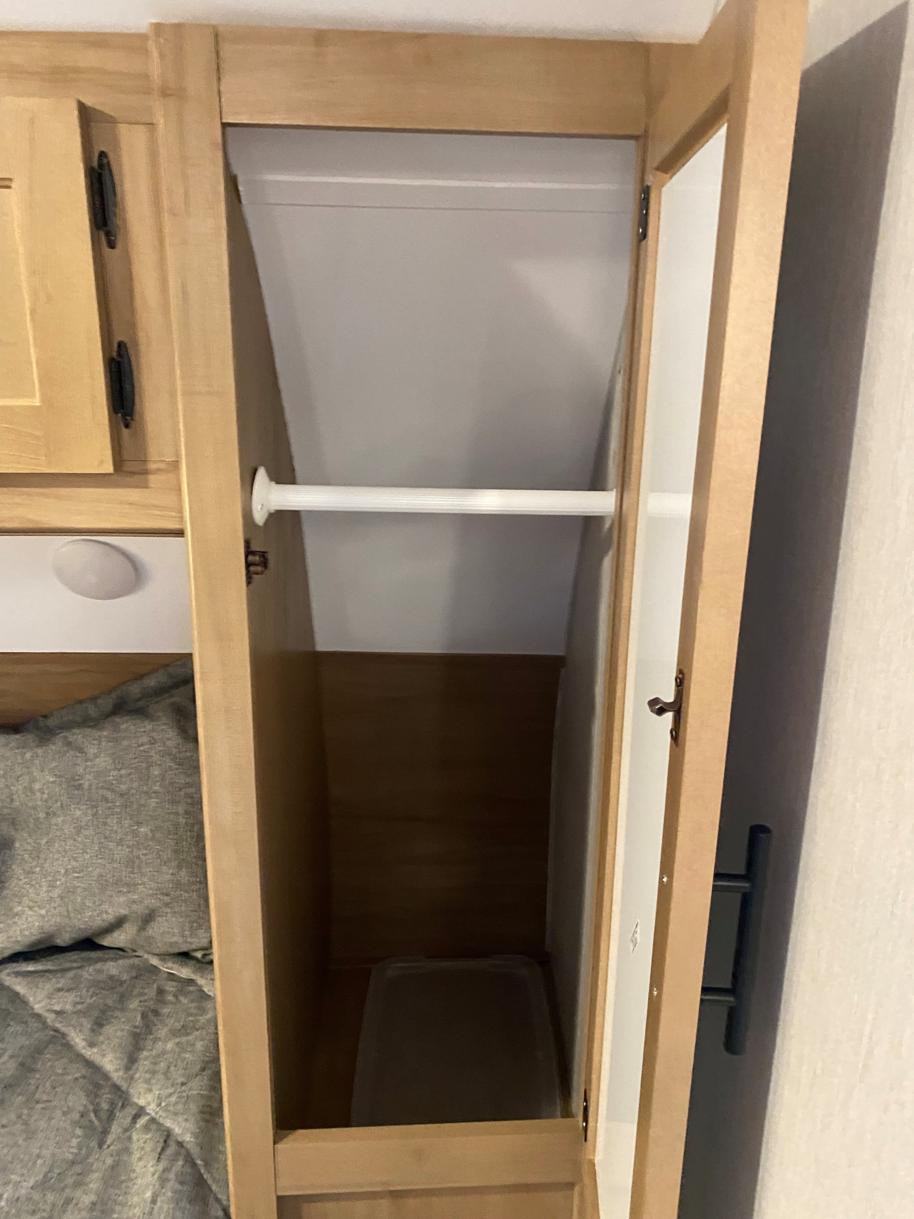 Open closet in an RV rental, featuring a light wood frame and white hanging rod for storage.. Forest River Cherokee Grey Wolf 2023