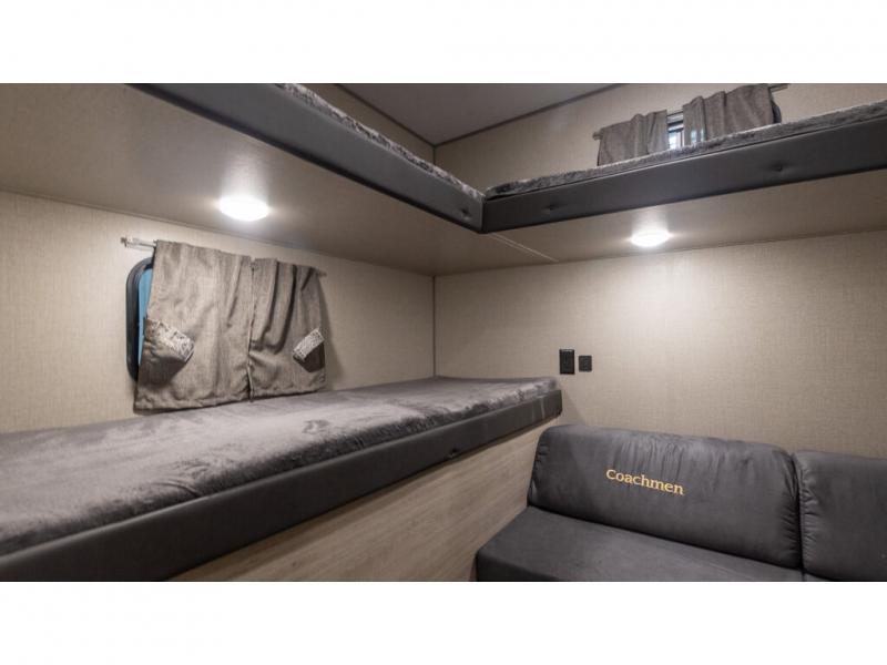 Step inside this RV rental's spacious bunkhouse featuring three beds, a comfy sofa, and window views.. Forest River Coachmen Catalina Legacy 2022