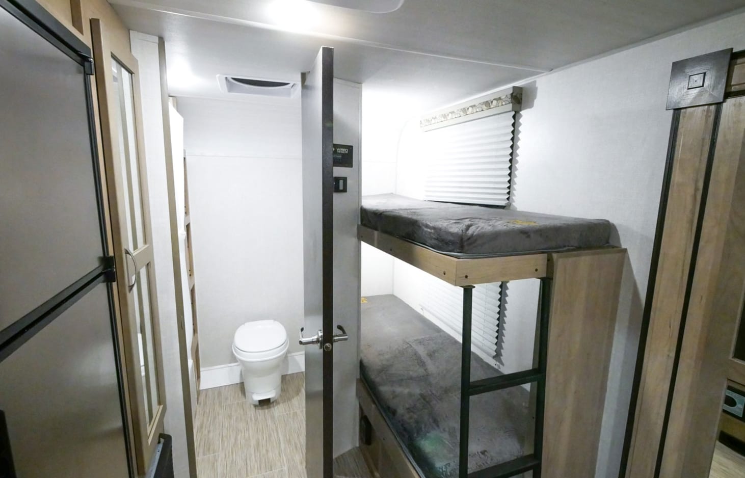RV rental interior features bunk beds, a compact bathroom with a toilet, and a refrigerator, optimizing travel space.. R-Pod R-Pod Trailer 2021