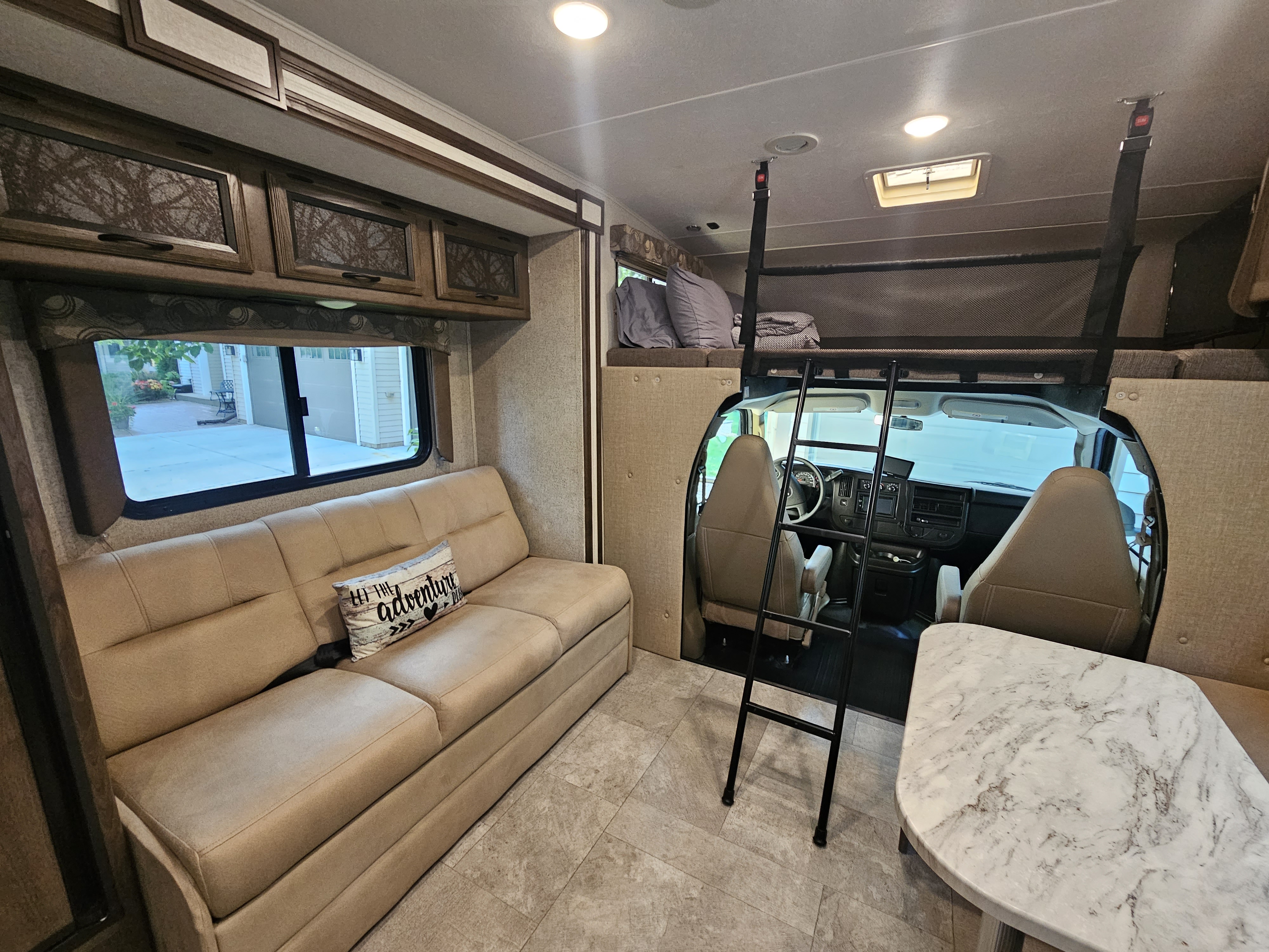 Inside this clean RV rental: a cozy pull-out sofa, overhead bunk bed, and dining table area. Ready for adventure.. Coachman Freelander 2019