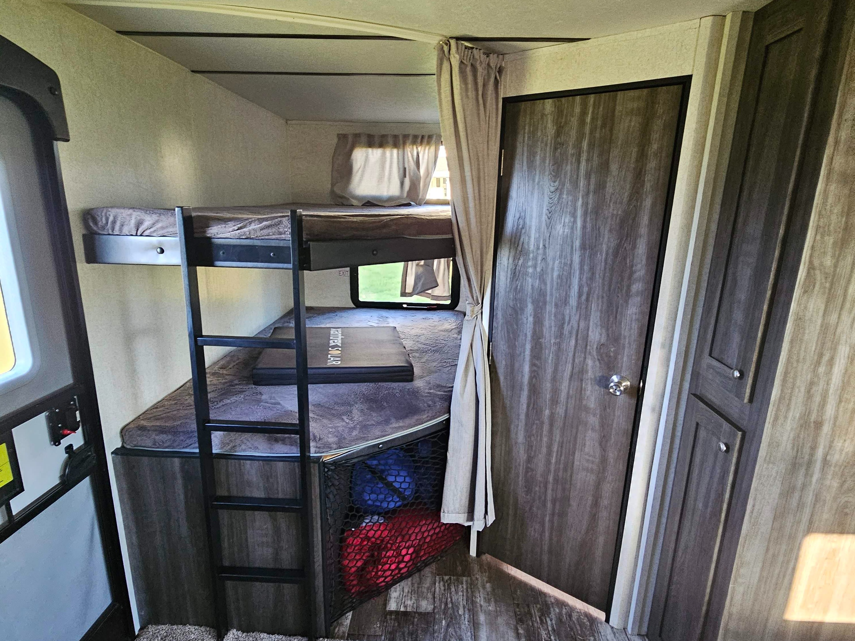 Cozy bunk beds and storage inside an RV rental, with a privacy curtain.. Starcraft Super Lite 2019