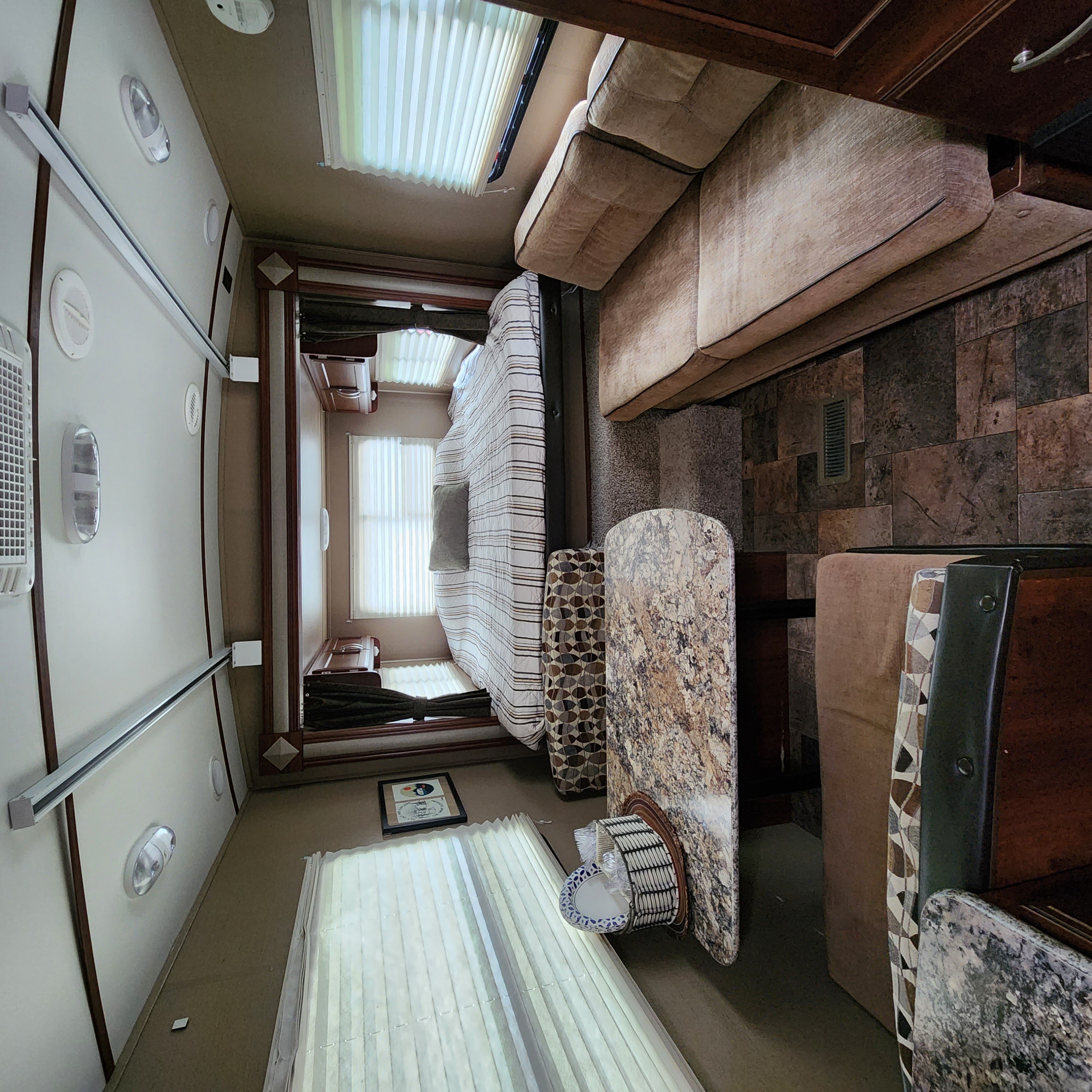 Explore this well-appointed RV rental interior, showcasing a comfortable living area, dining space, and bedroom setup.. Keystone RV Outback Terrain 2014