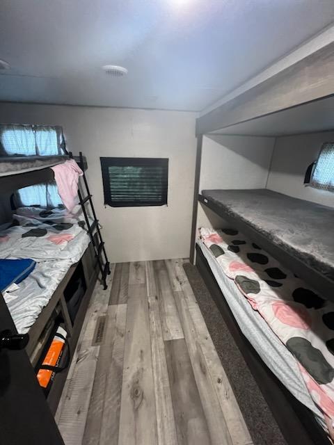 This RV rental bunk room features two sets of beds, a ladder, window, and wood-look flooring, offering compact family sleeping.. Sportsmen SE 2021