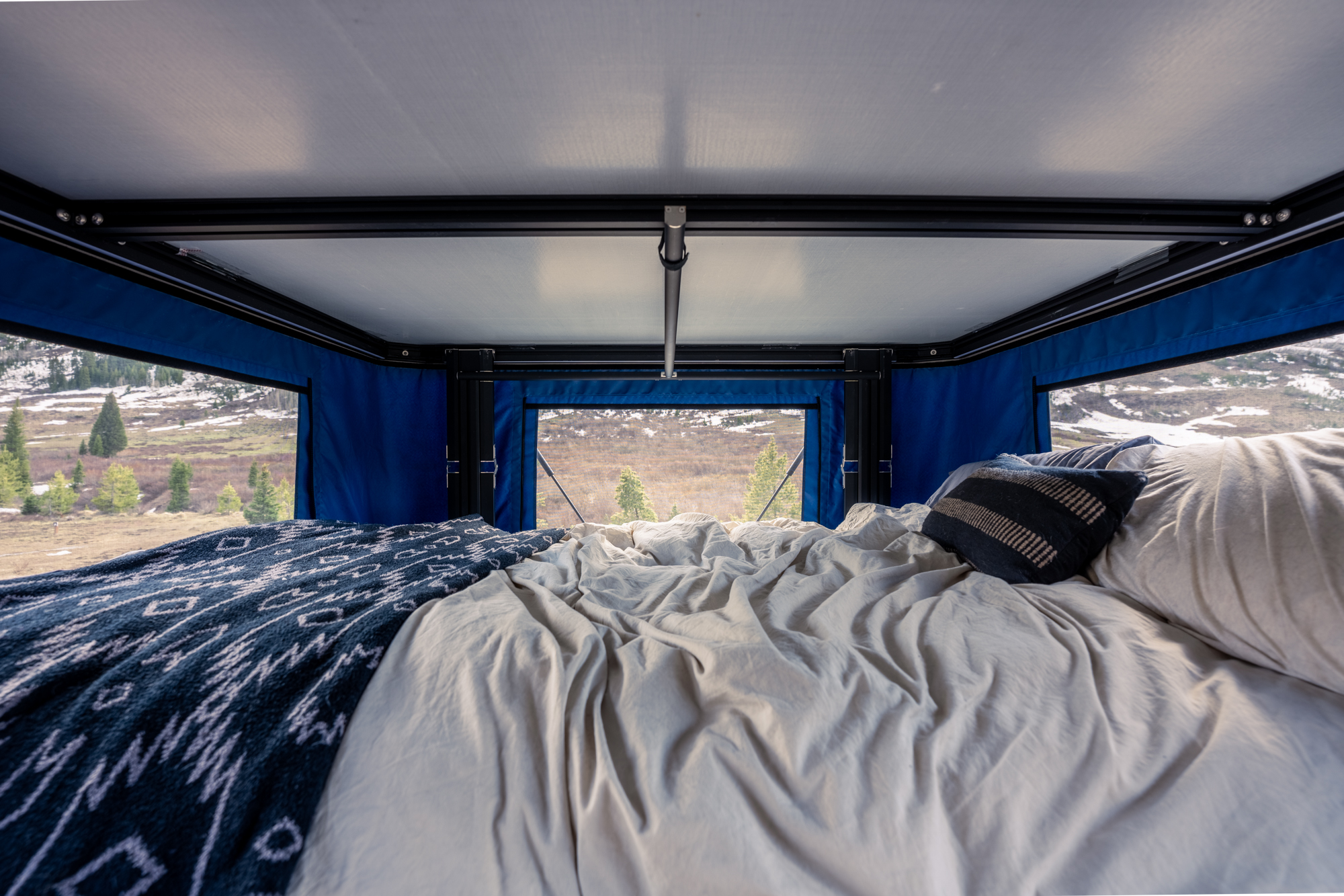 Enjoying an RV rental! A cozy bed inside a rooftop tent offers stunning nature views. Ideal for camping and travel.. Toyota Tacoma 2022