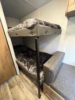 Cozy RV rental bunk beds. This sleeping area features two stacked beds with plush gray blankets, perfect for family adventures.. Forest River Cherokee 2024