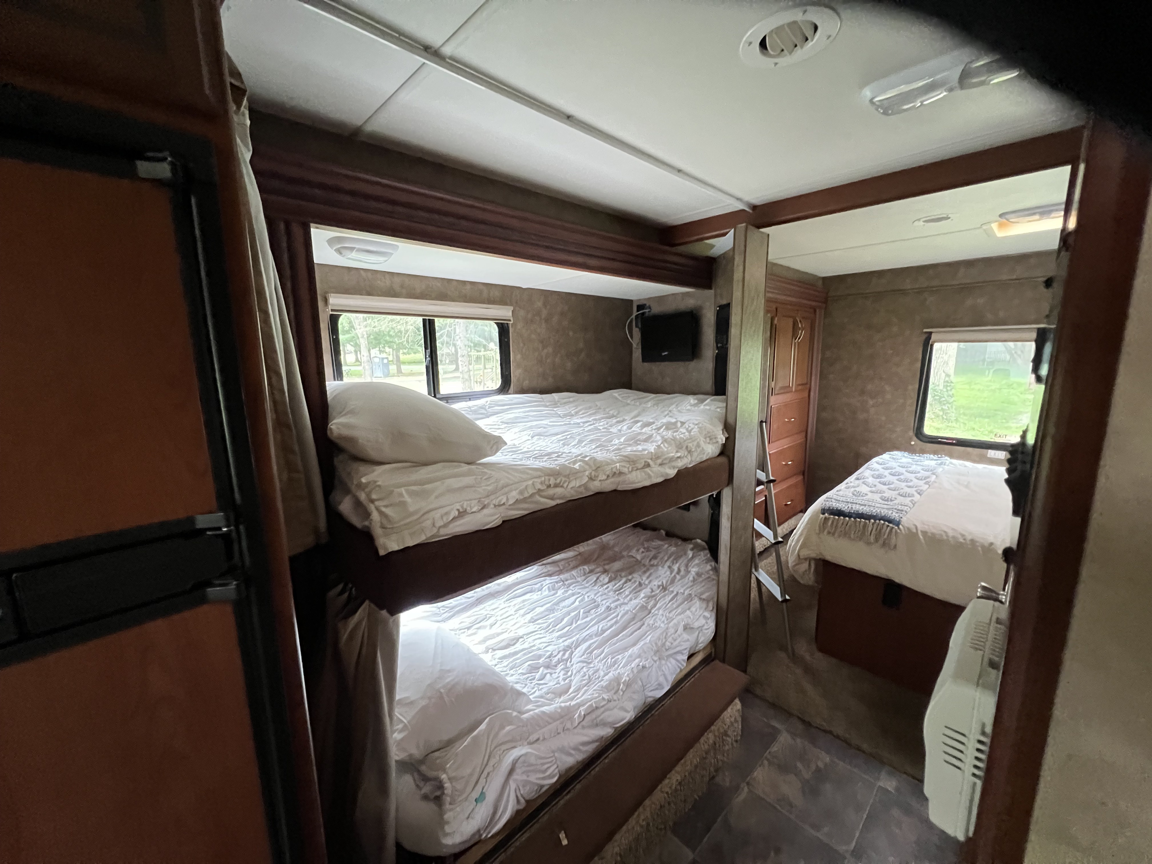 Inside this RV rental: comfortable bunk beds, a master bed, and window views. Ideal for family road trips.. Thor Chateau 2013