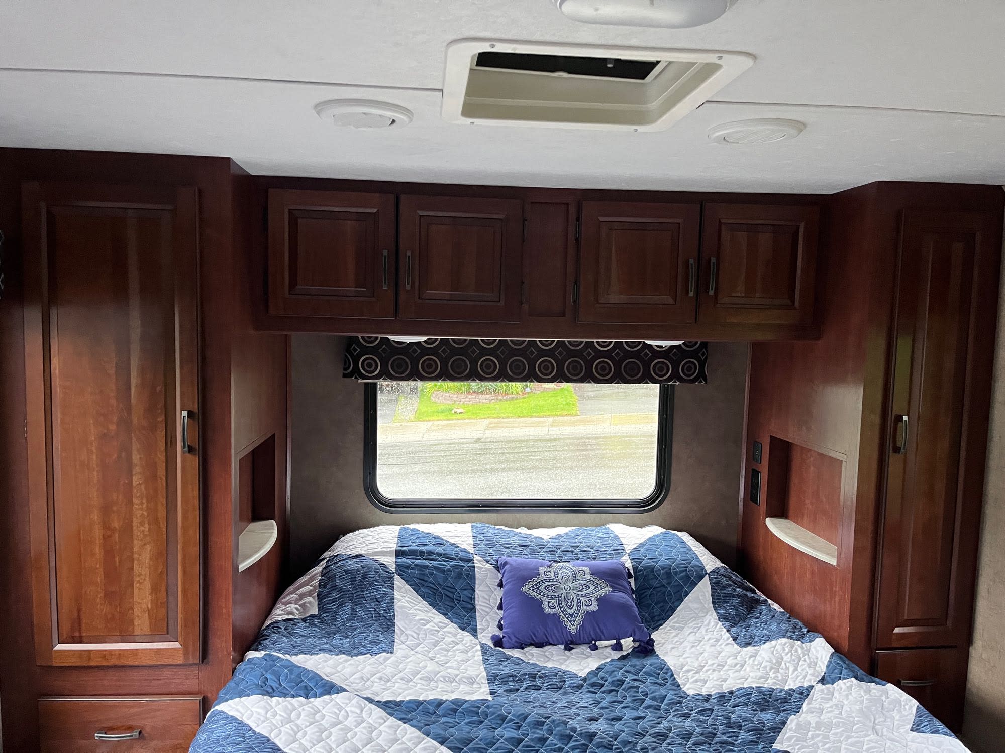 Cozy RV rental bedroom with a comfy bed, window, and storage. Perfect for travel adventures.. Forest River Sunseeker 2017