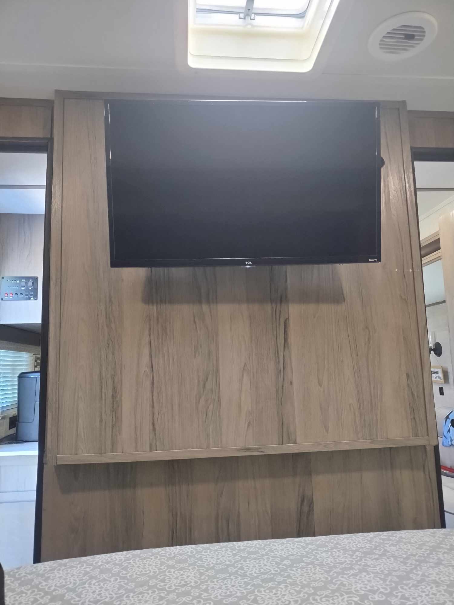 RV rental bedroom interior with wall-mounted TV, skylight, and control panel. Cozy space for your next trip.. Gulf Stream Ameri-Lite 2021