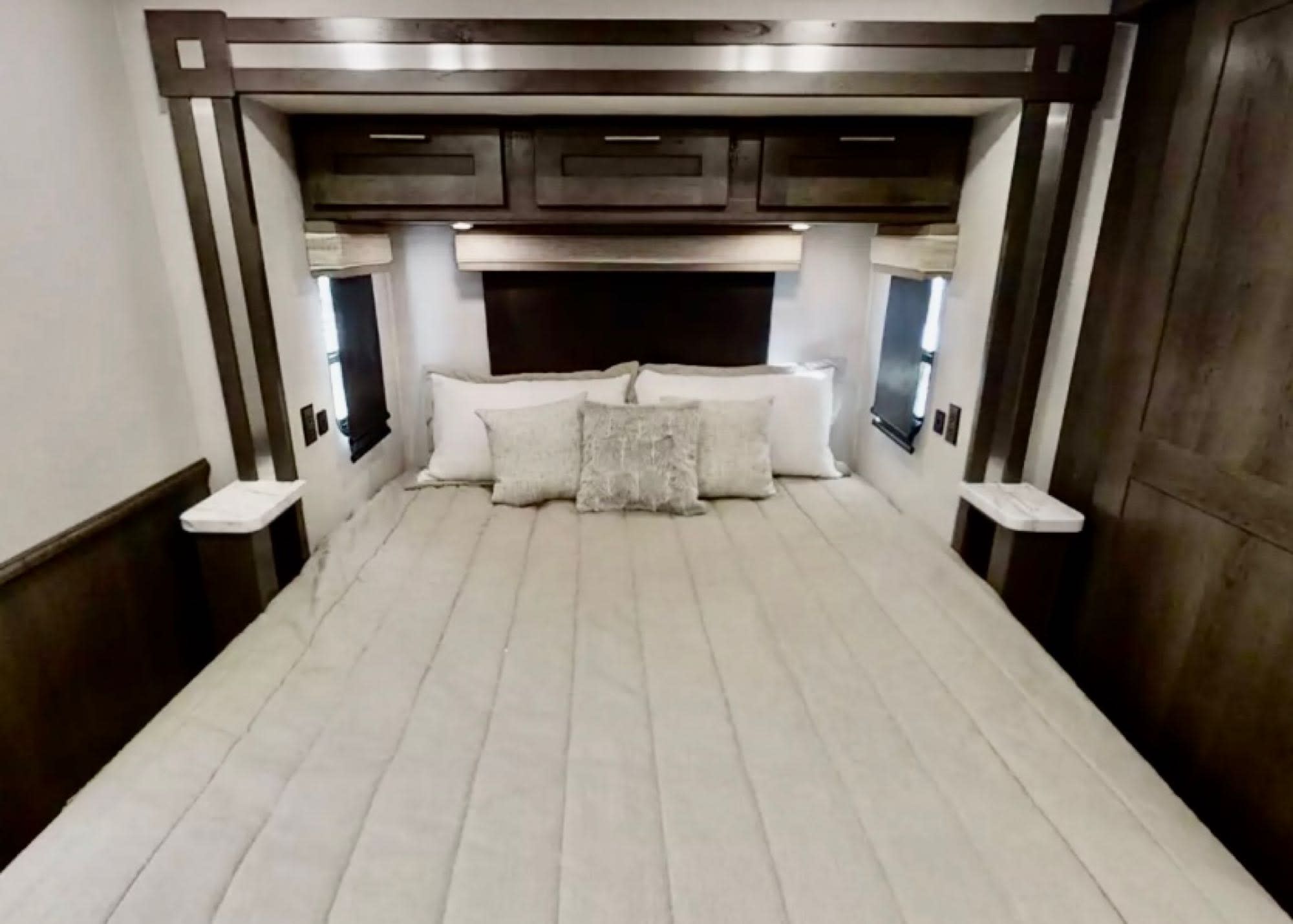 Cozy RV rental bedroom with queen bed, overhead storage, and windows for a comfortable stay.. Forest River Georgetown 5 Series 2023