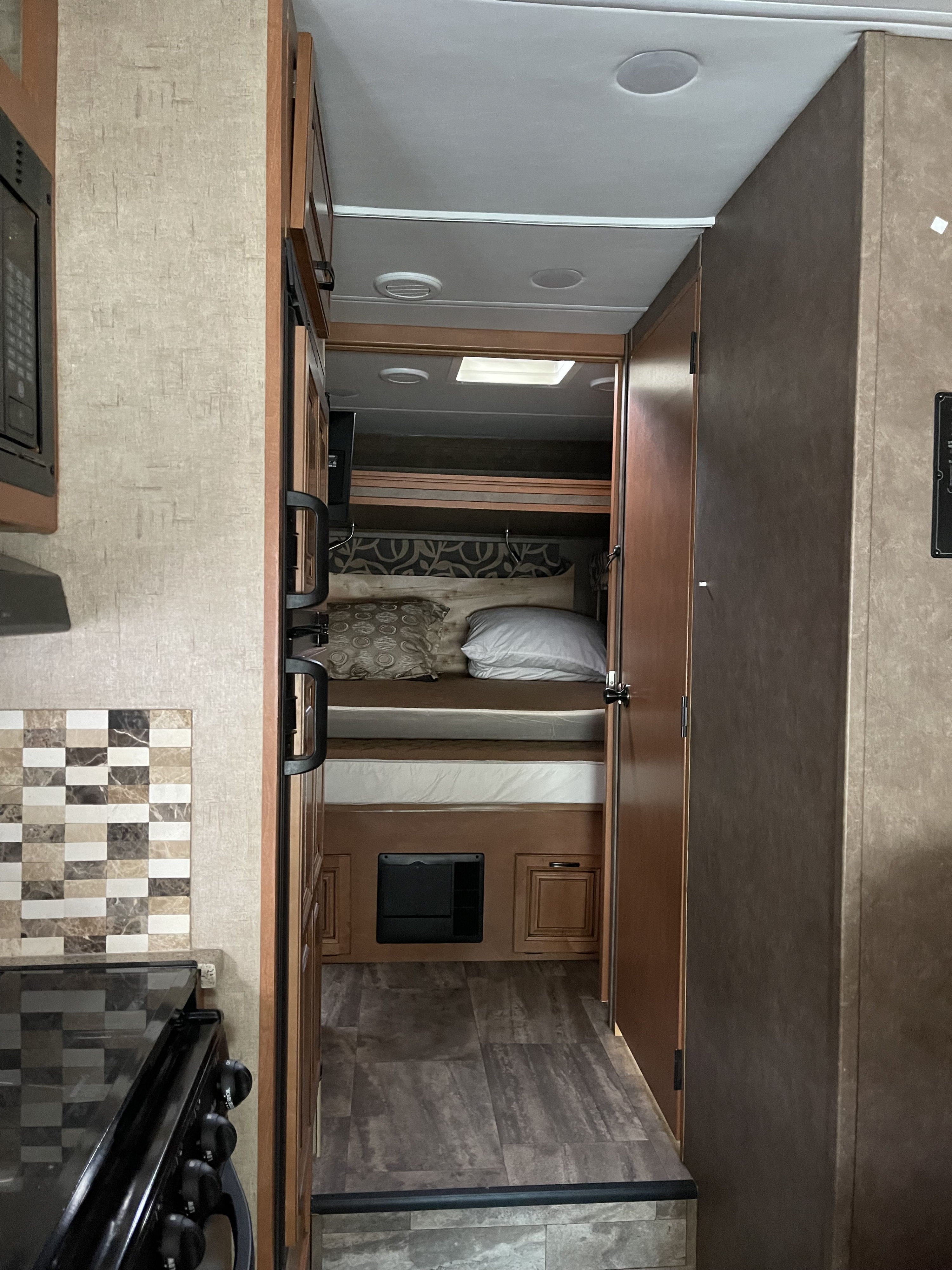 Inside an RV rental: view from the kitchen, through the hall, to bunk beds. Features include a tiled backsplash & ceiling lights.. Forester Forester Motorhome 2016