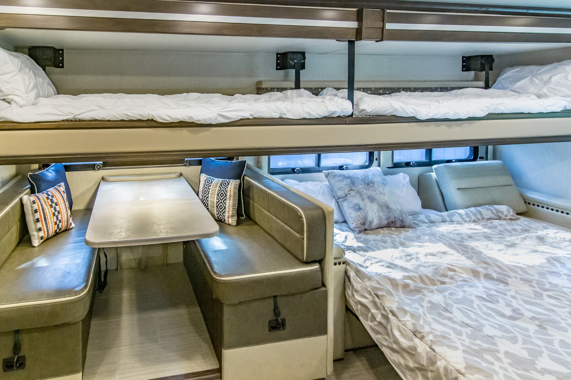 Inside this RV rental: two bunk beds, a dinette table with seating, and a convertible bed, optimizing space for travel comfort.. Coachmen Mirada 2020