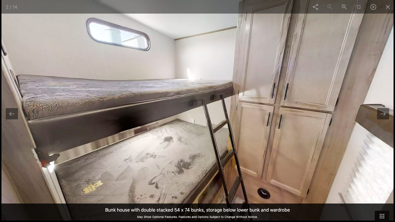RV rental bunk room showing double stacked beds, built-in storage below, and a wardrobe for comfortable family stays.. Forest River Cherokee Arctic Wolf 2021