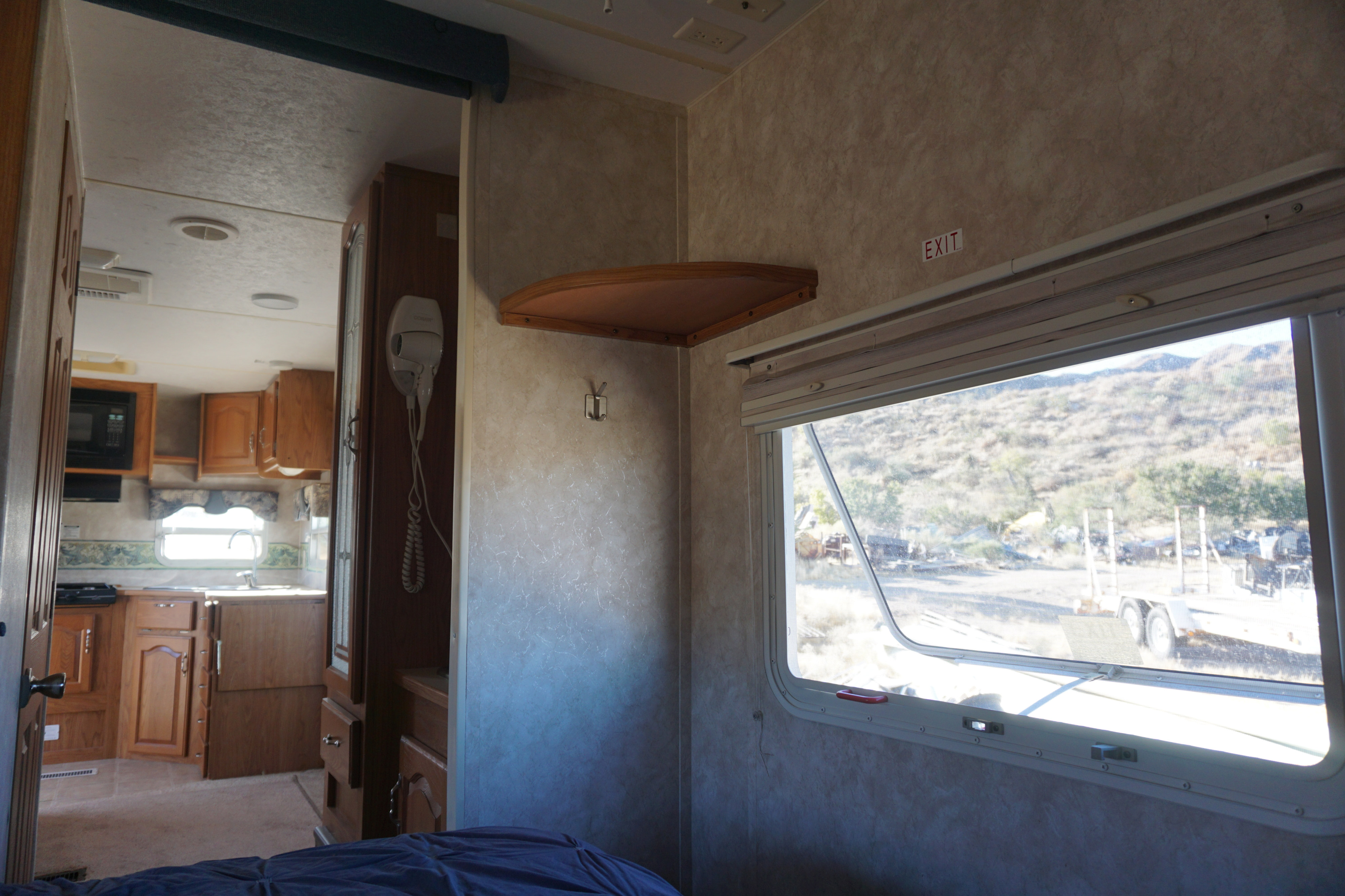 RV rental interior: Looking from the bedroom into a compact kitchen, with a large window. Keystone RV Sprinter 2004