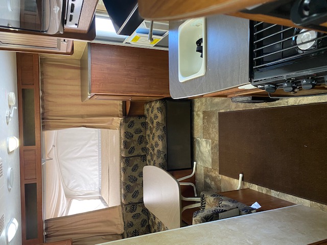 Inside this rv rental: a compact kitchen, dining area, and a tent pop-out bed, ready for your next adventure.. Jayco Jay Feather Ultra Lite 2012