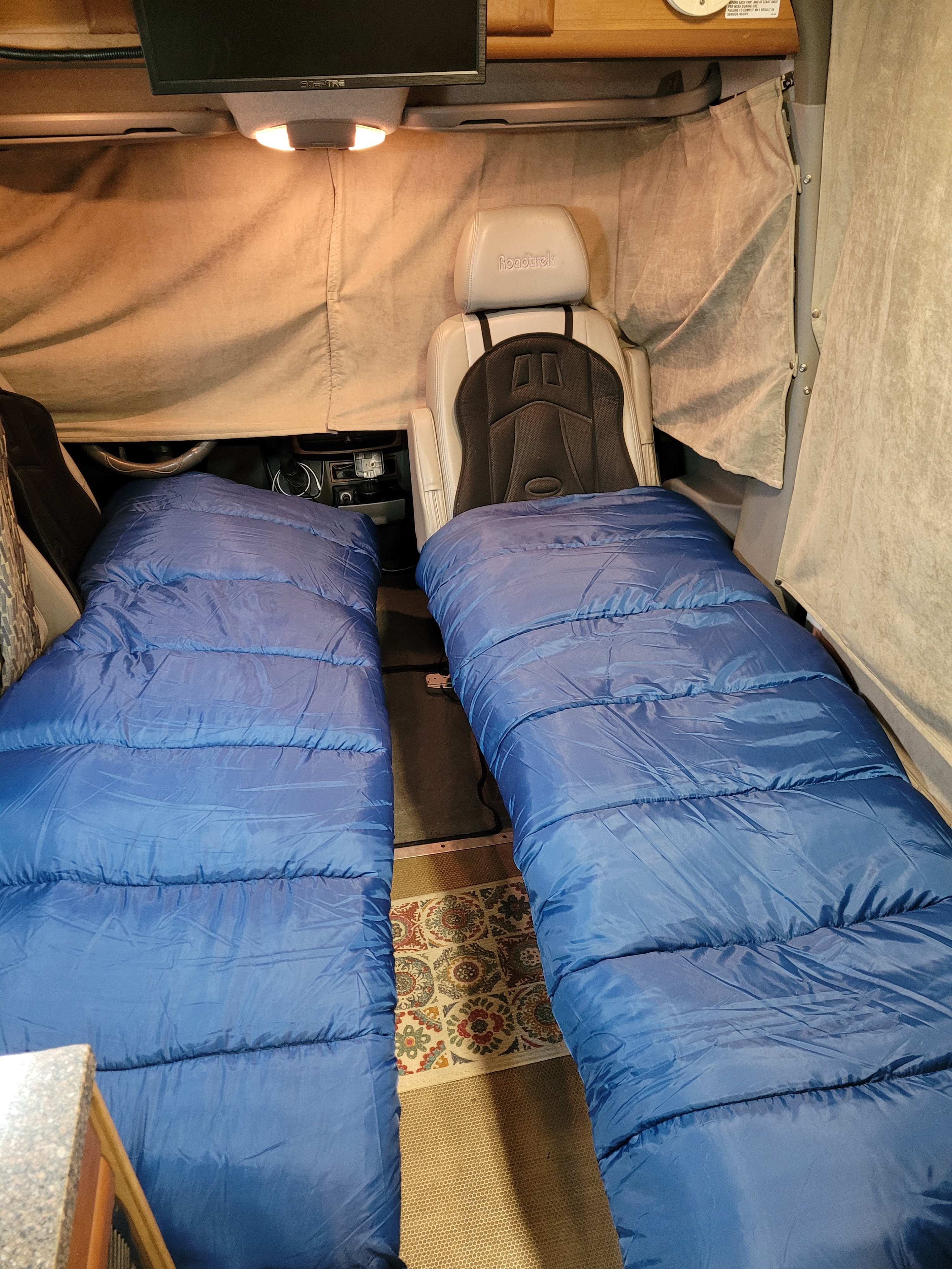 Two blue sleeping bags laid out in this cozy RV rental's camper van interior, perfect for overnight travel.. Roadtrek Roadtrek Class B 2011