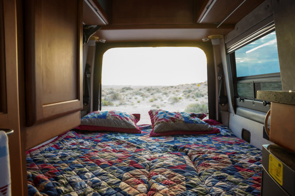 Experience adventure! This RV rental bedroom offers a colorful quilted bed & expansive desert views from its rear window.. Roadtrek Roadtrek Class B 2011