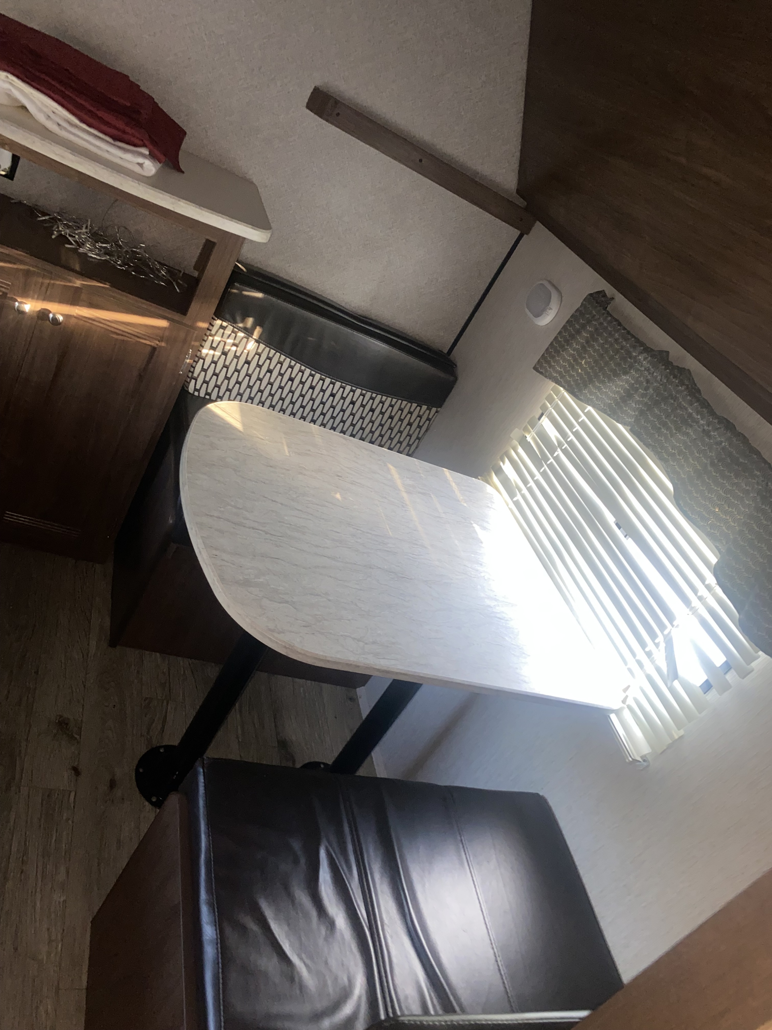 RV rental dinette: A functional interior featuring a light table, comfortable bench seating, and a sunlit window.. Heartland RVs Prowler Lynx 2018