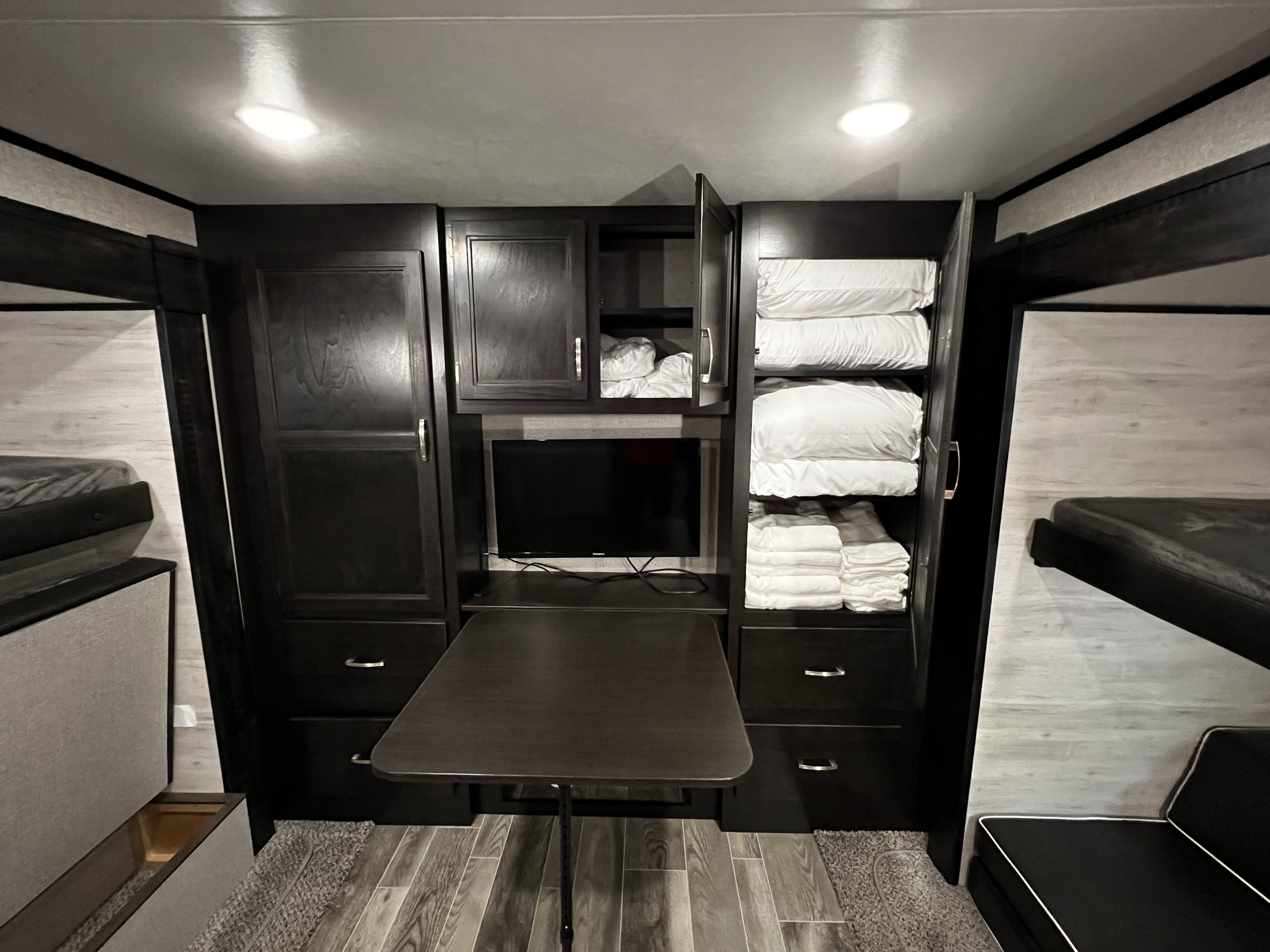 RV rental interior: a compact bunkhouse with TV, folding table, and ample storage for comfortable travel.. Jayco Jay Flight 2021