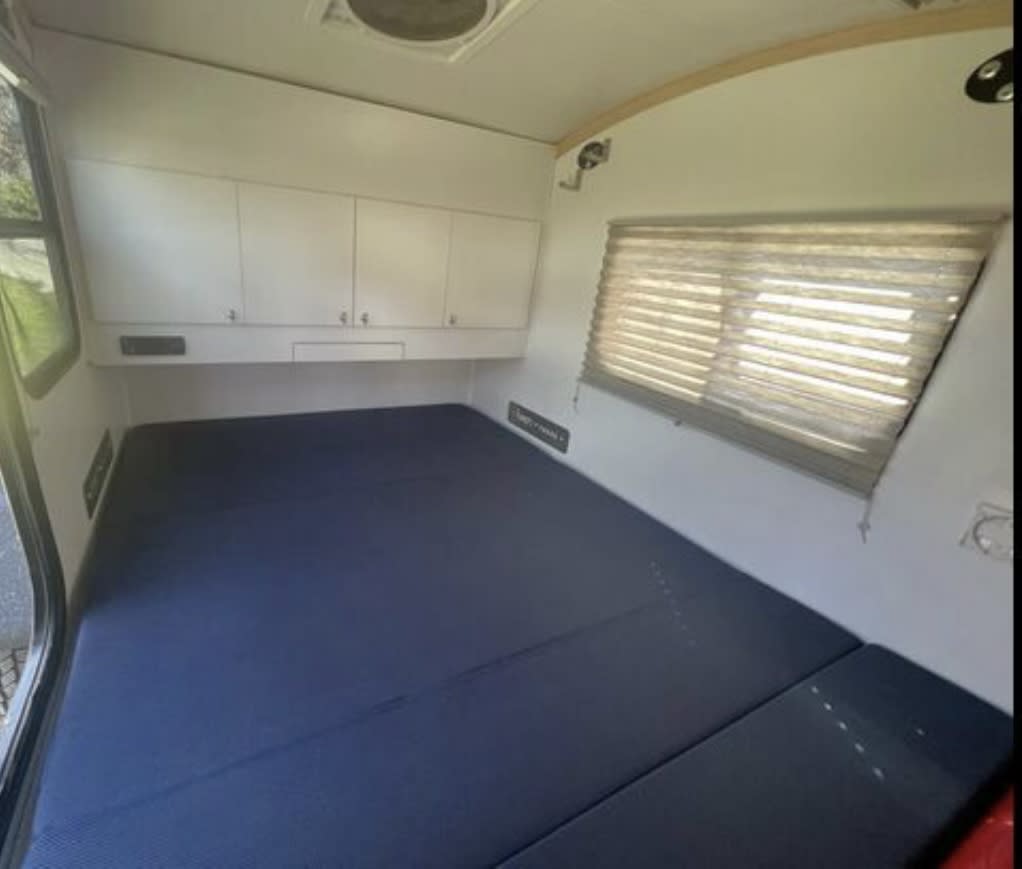 Spacious RV rental interior featuring a large bed, overhead cabinets, and window blinds, ready for comfortable travel.. Bean Meaner Bean 2018