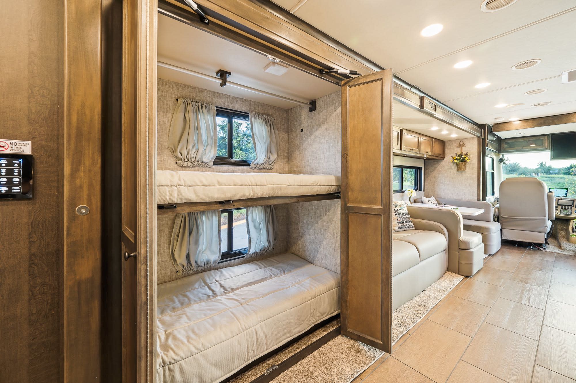RV rental with enclosed bunk beds and a bright, inviting living space, showcasing a spacious motorhome interior.. Tiffin Open Road 36UA 2023