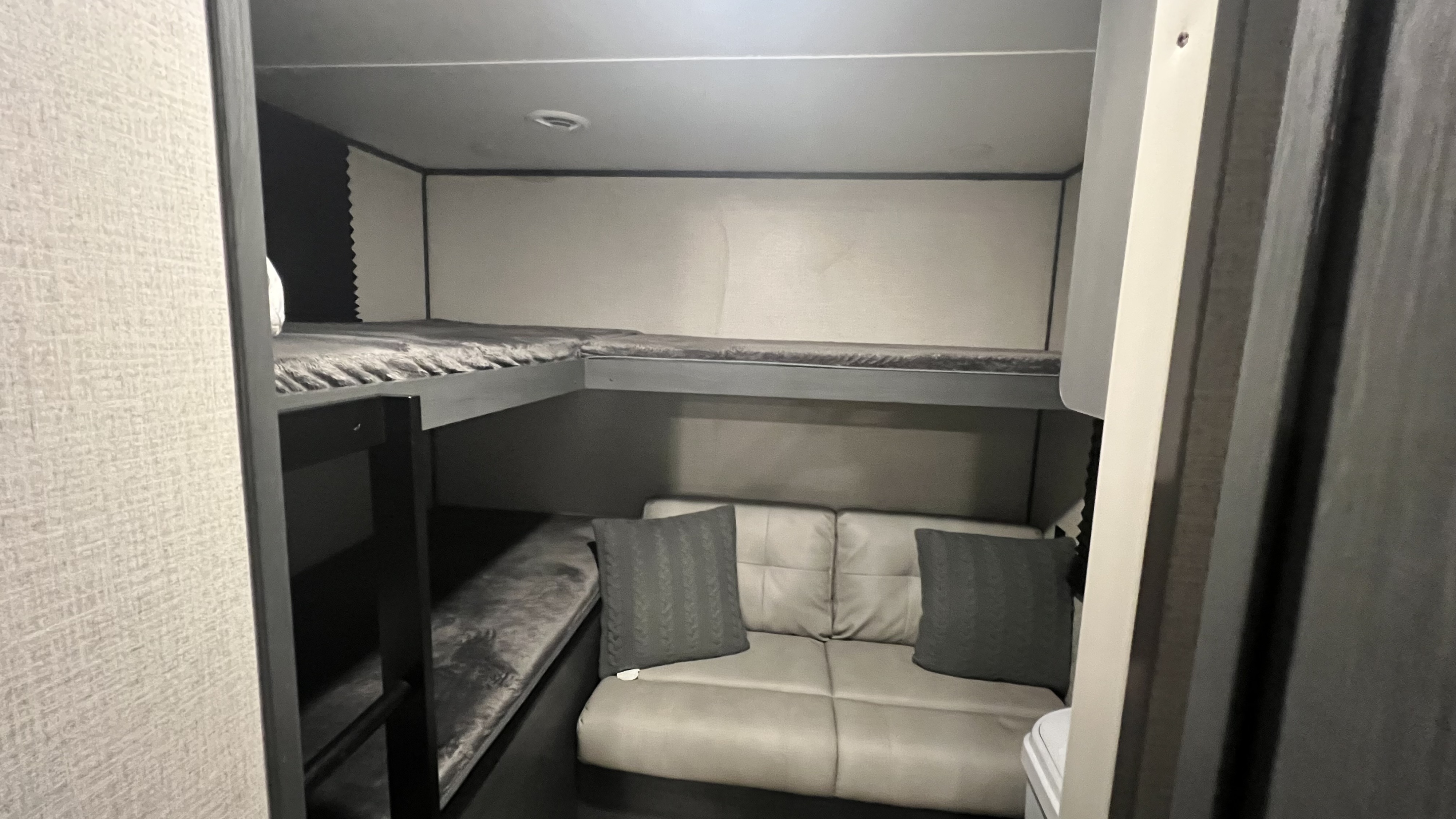 Inside this RV rental: a smart layout with two bunk beds and a comfy sofa offers practical sleeping and seating space.. Dutchmen Colorado 29BHC 2021