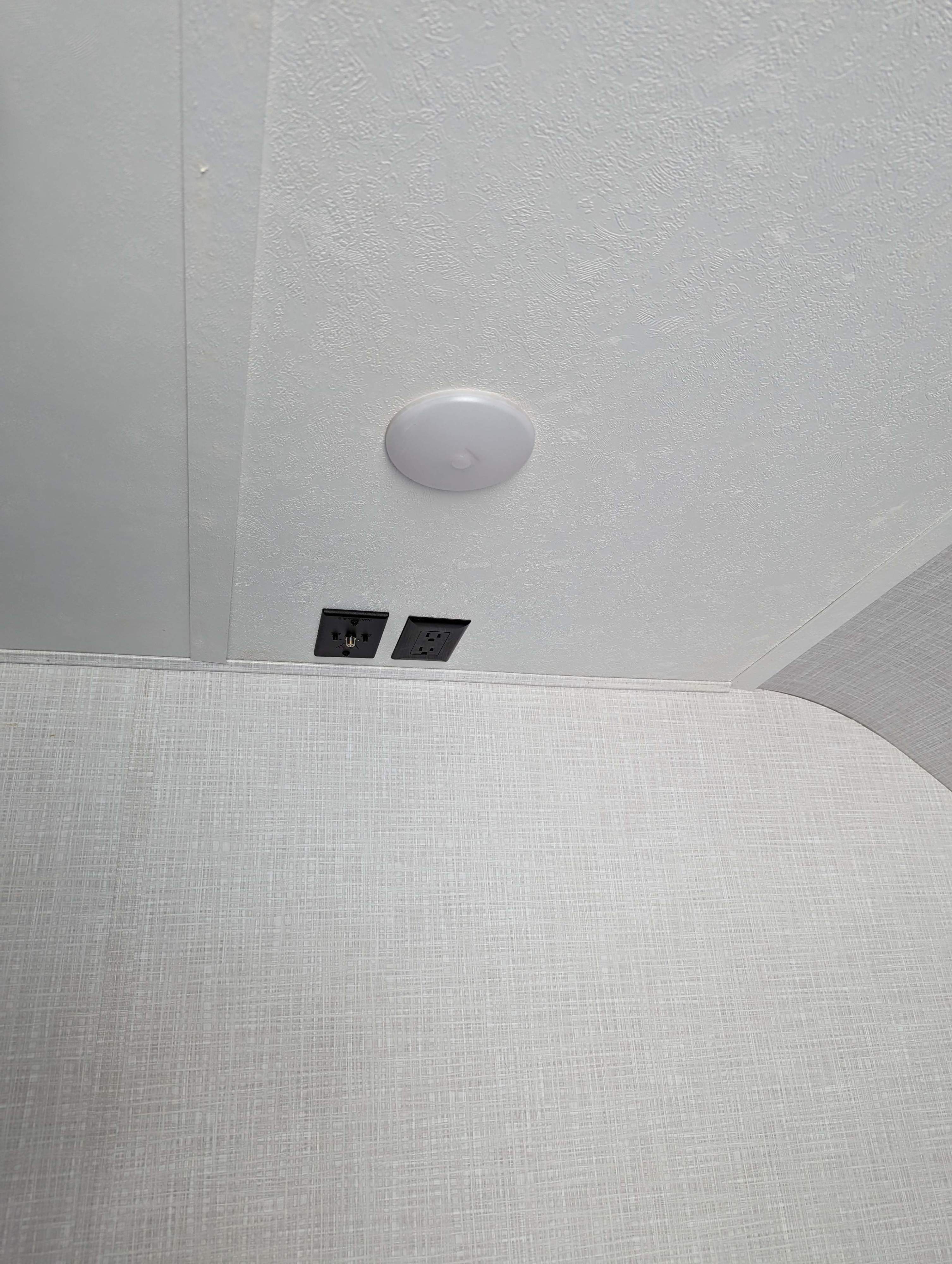 RV rental: Bright ceiling light, AC power, and coaxial outlets on a textured wall for your entertainment setup.. Dutchmen Coleman Light 2022