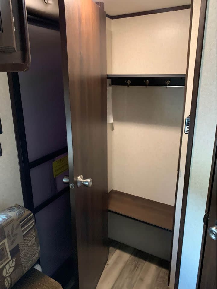 Inside an RV rental: a practical closet with bench seat and coat hooks, perfect for organizing belongings.. Jayco Jay Flight SLX 2018