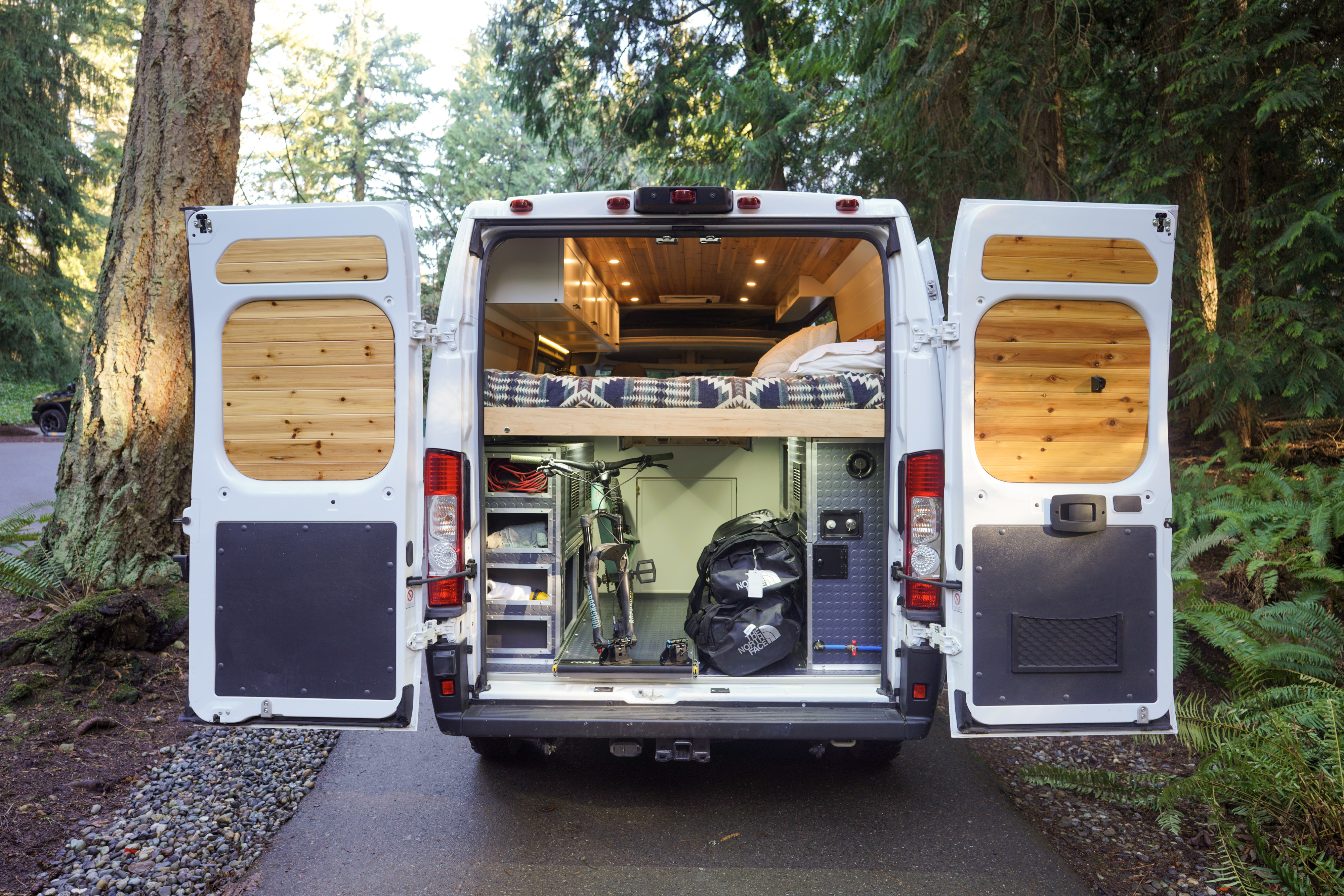 Adventure-ready RV rental: See inside this custom van conversion with bed, bike storage, and wooden details.. Dodge RAM Promaster 1500 2020