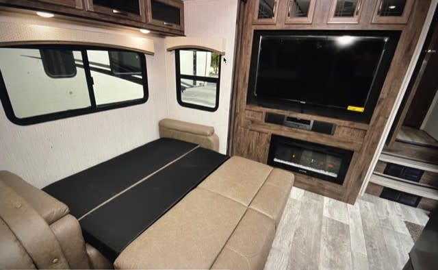 RV rental: Interior showing a convertible sofa bed, large TV, fireplace, and windows.. Forest River Sierra C-Class 2020