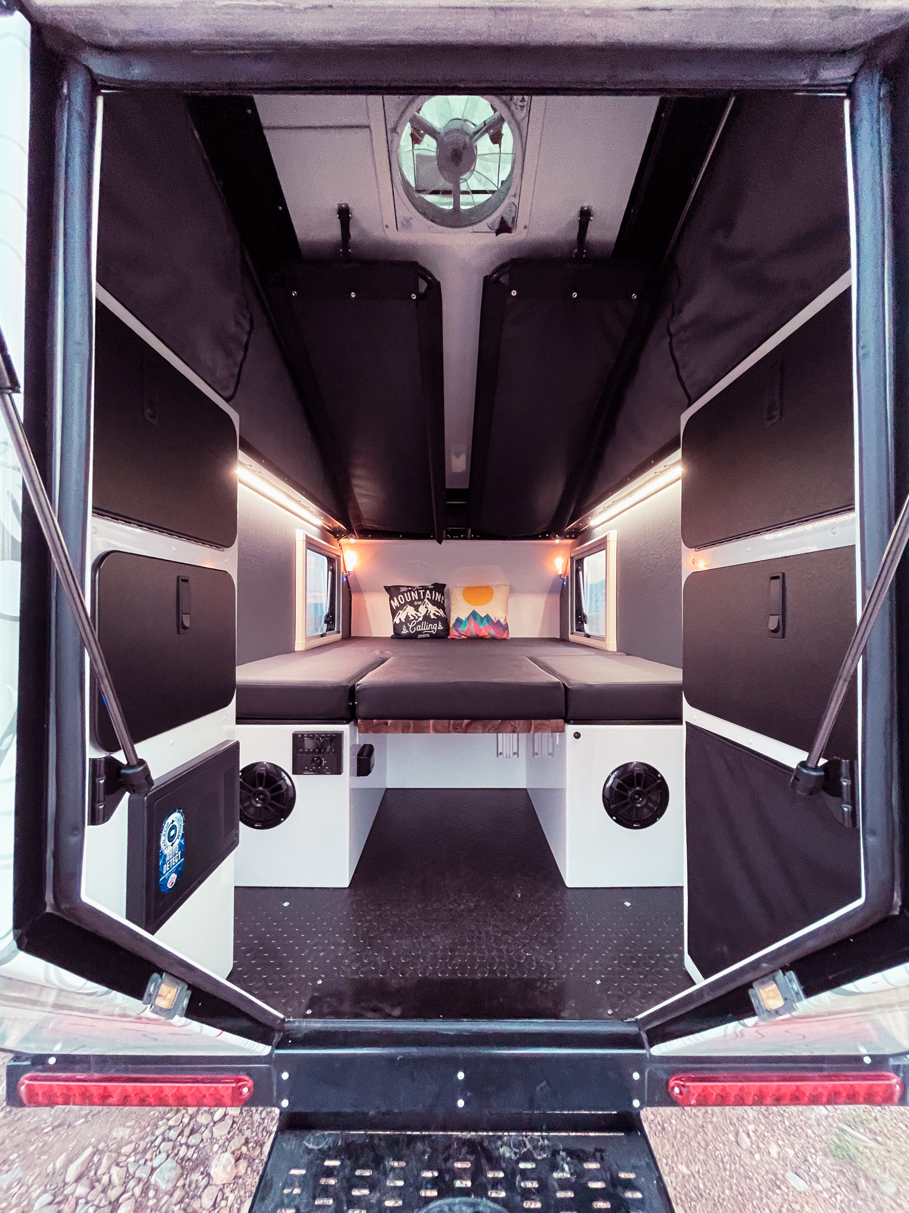 Inside this RV rental, discover a well-designed camper interior with a comfortable bed, convenient storage, and ventilation.. Mission Overland Summit 2022