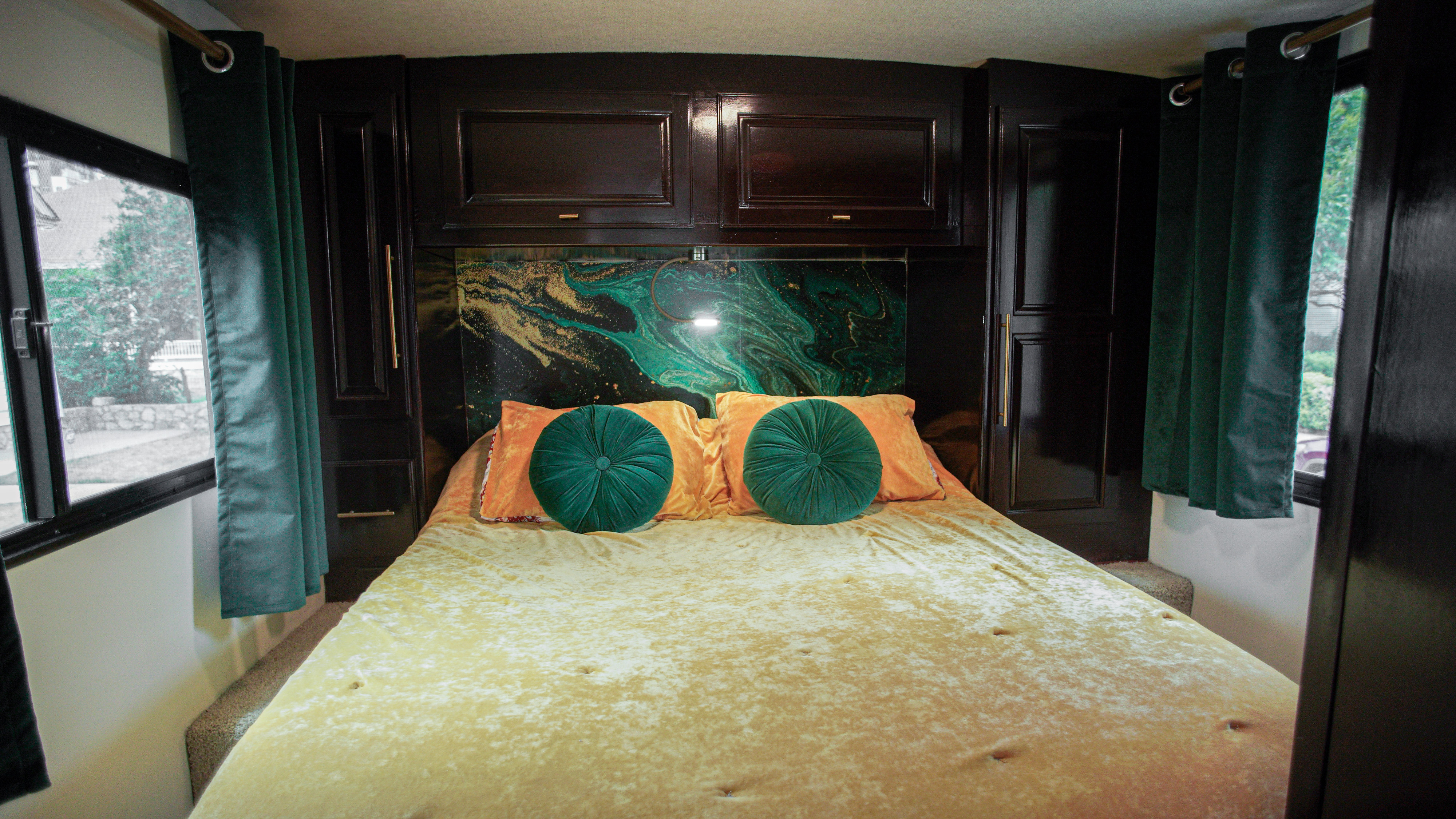 Luxurious RV rental bedroom with dark wood, gold bed, and teal accents for a cozy, stylish interior.. Itasca Sunstar 2014