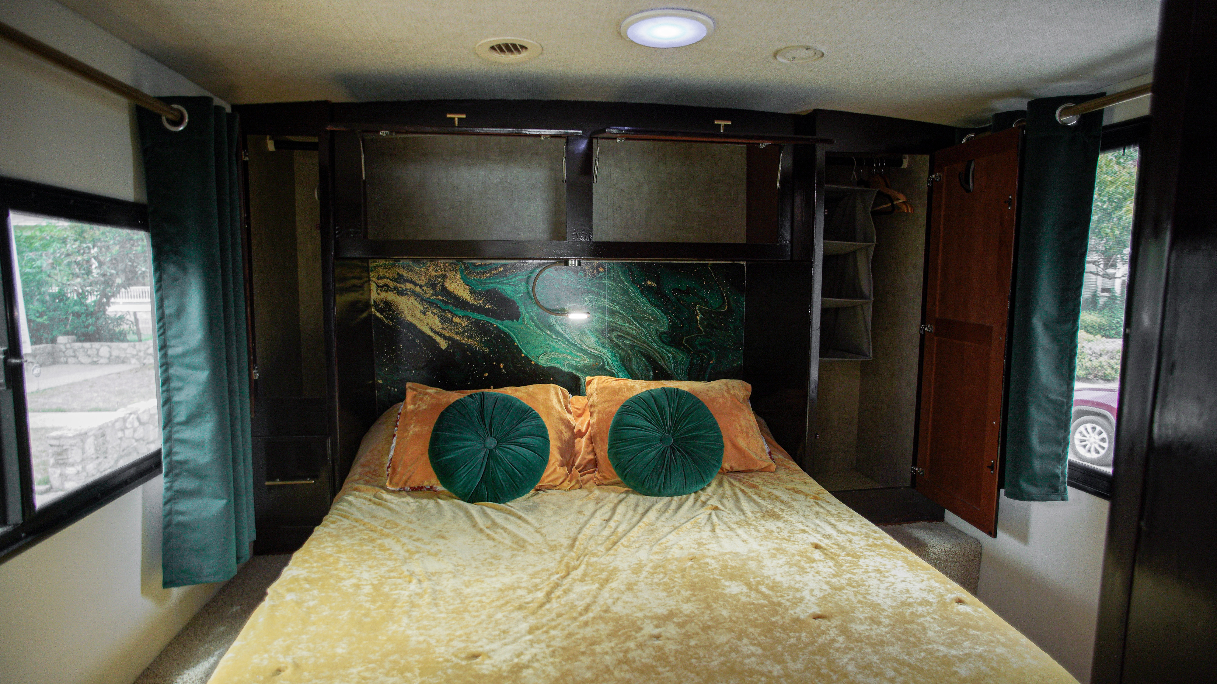 This cozy RV rental bedroom offers a plush gold bed, artistic headboard, and convenient storage.. Itasca Sunstar 2014