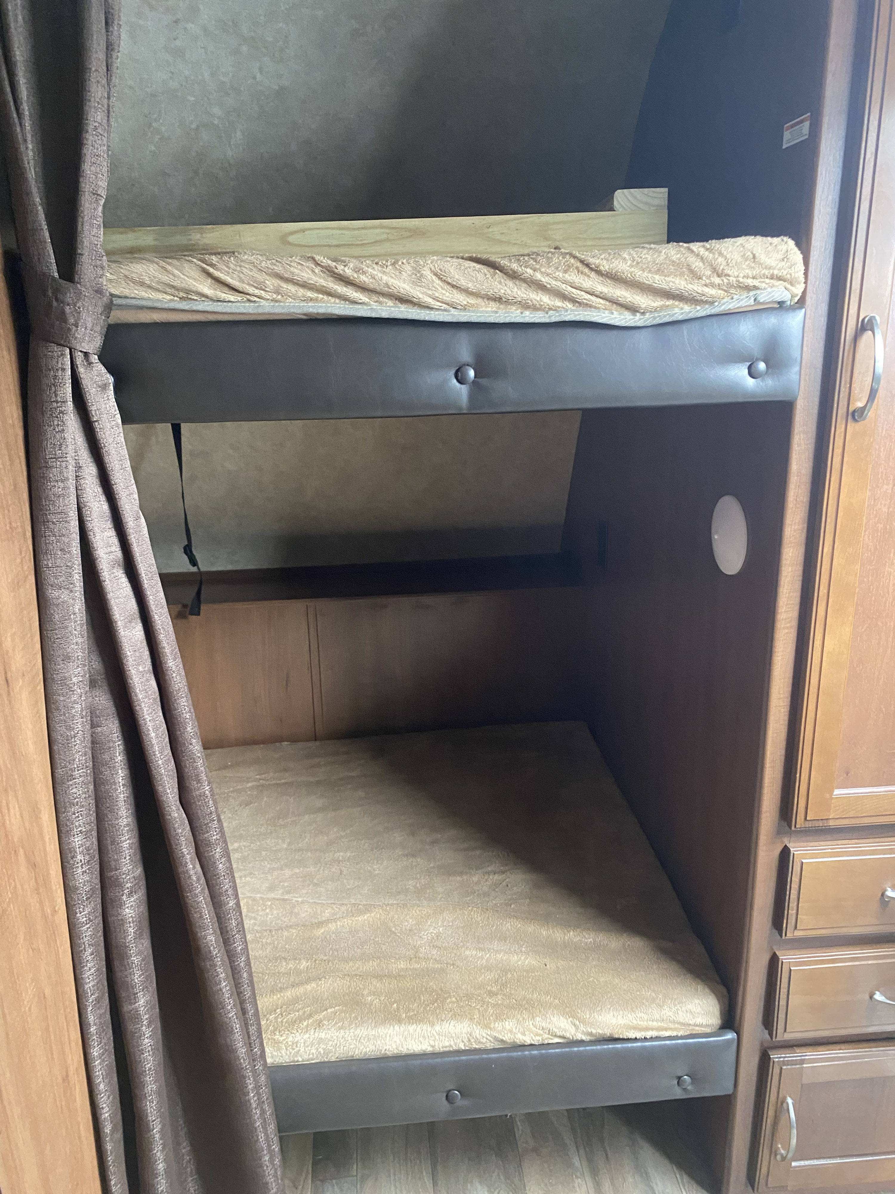 Cozy RV rental bunk beds, perfect for family sleeping. Features upper & lower bunks, privacy curtain, and built-in storage.. Jayco Jay Feather 2017