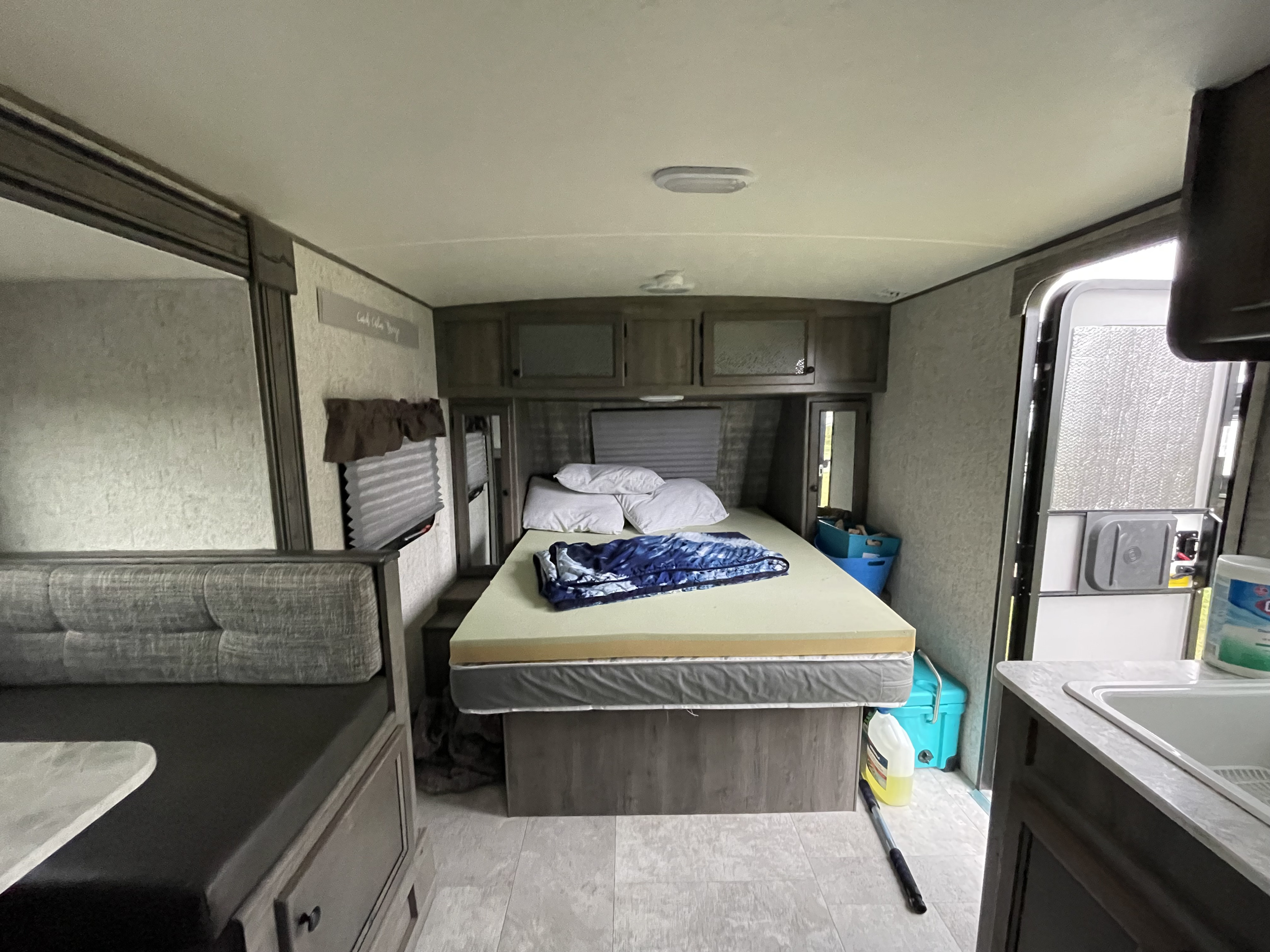 This RV rental interior features a cozy bedroom, dinette, and sink area, perfect for travel.. Coachmen Apex Nano 2019