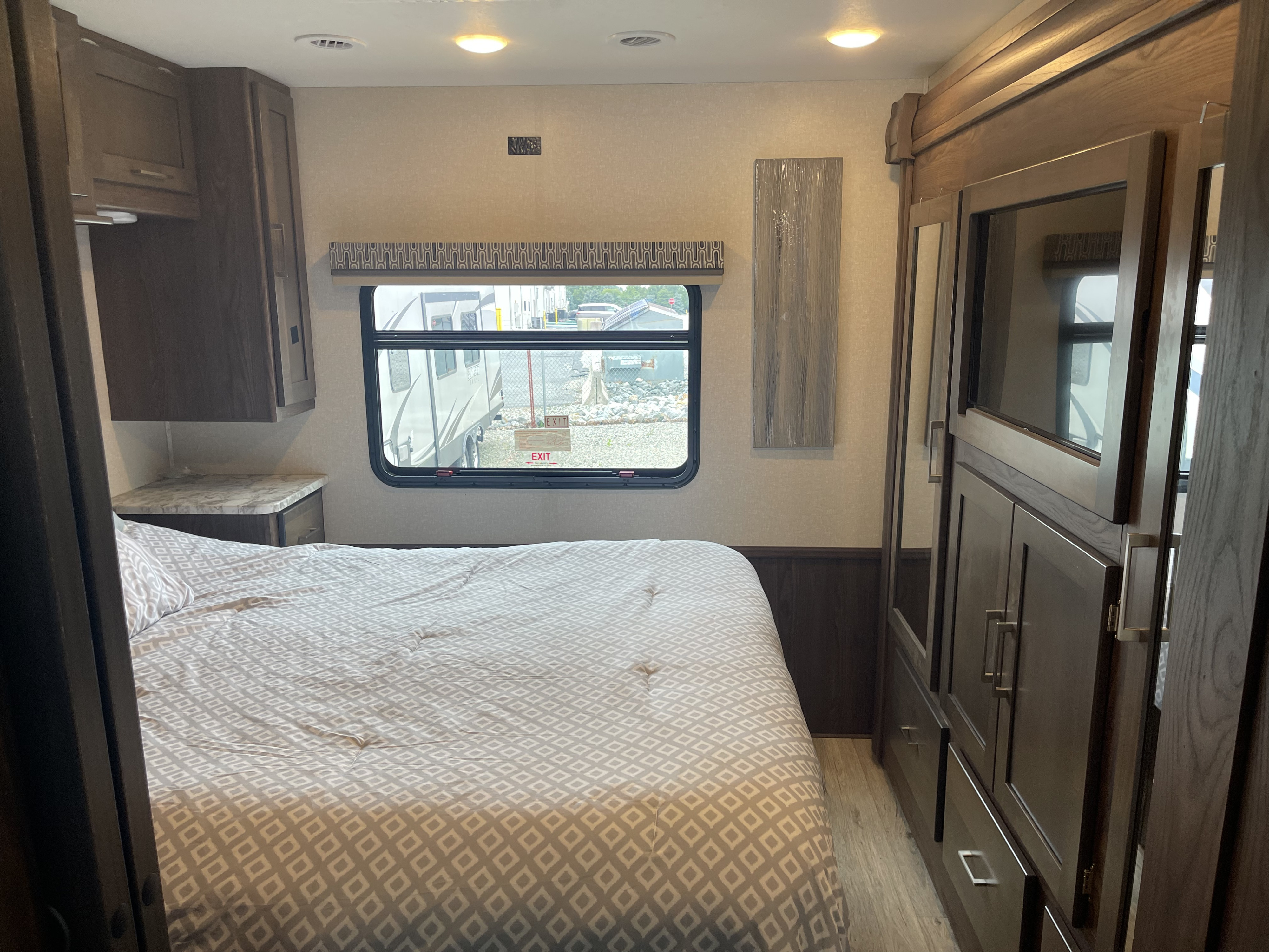 Spacious RV rental bedroom with ample storage cabinets, a comfortable bed, and a large window for natural light.. Pursuit 29SSP 2020