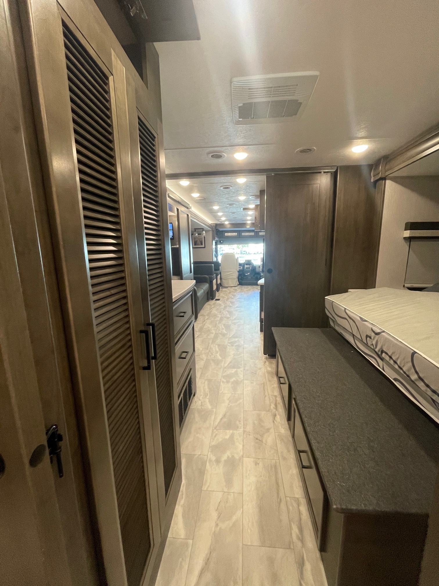 Explore this RV rental's interior: a comfortable hallway with ample storage, a bed area, and modern finishes.. Coachmen Mirada 2026