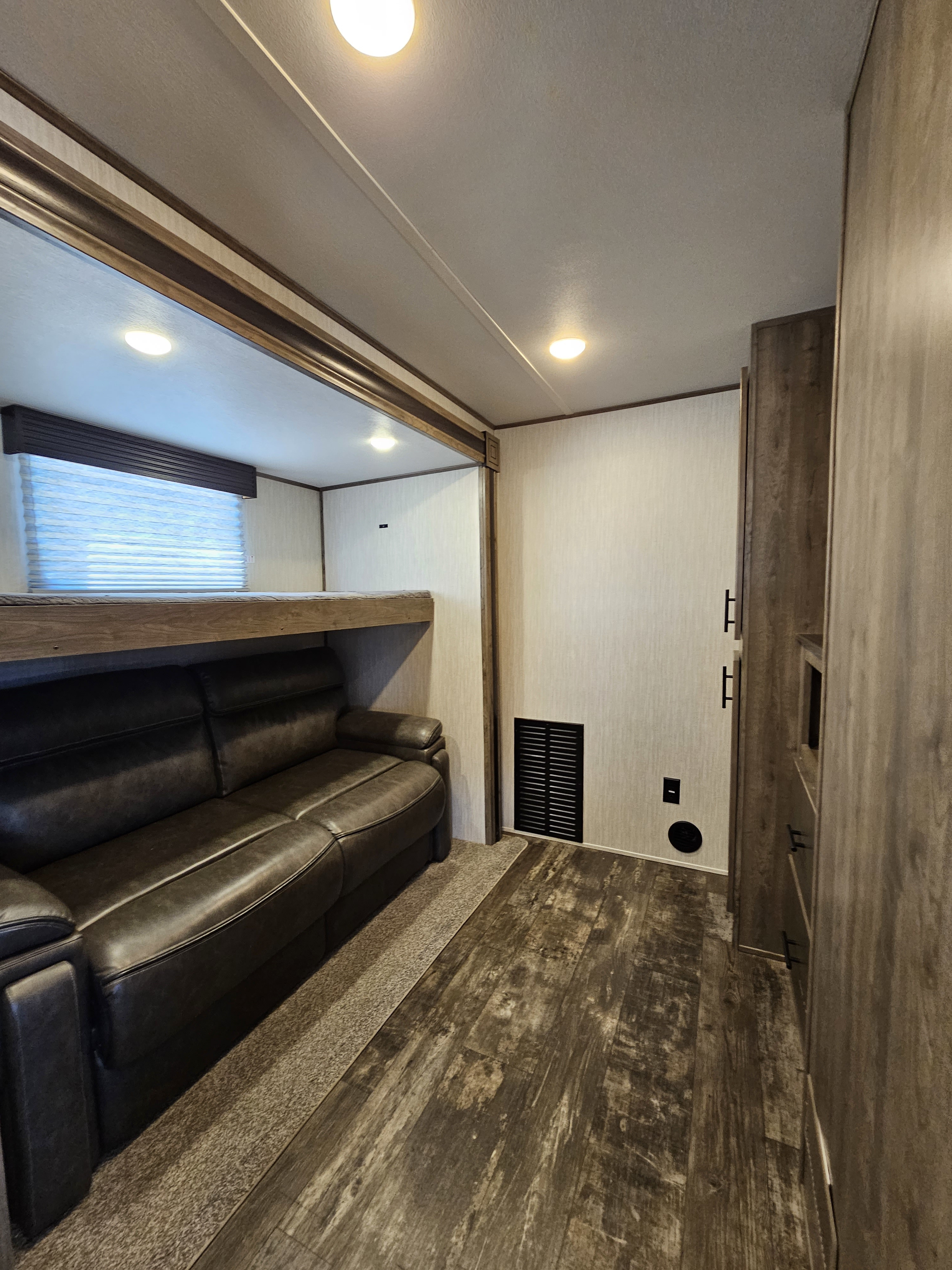 Cozy RV rental interior: sofa, bunk bed, and wood flooring provide comfortable living space for your adventure.. Forest River Sabre 2020