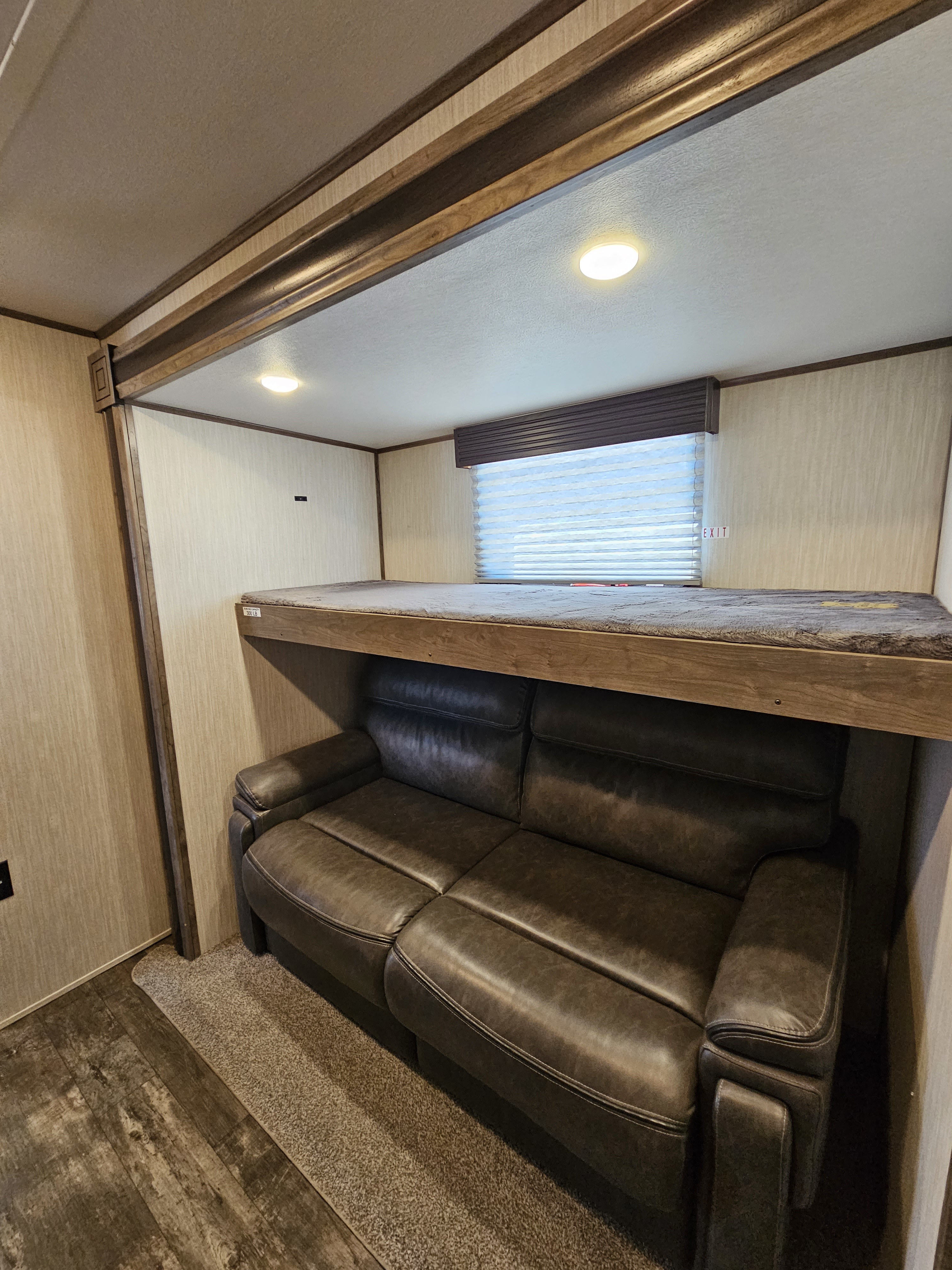 RV rental: dark sofa beneath a bunk bed, offering comfortable seating and sleeping space in this camper interior.. Forest River Sabre 2020