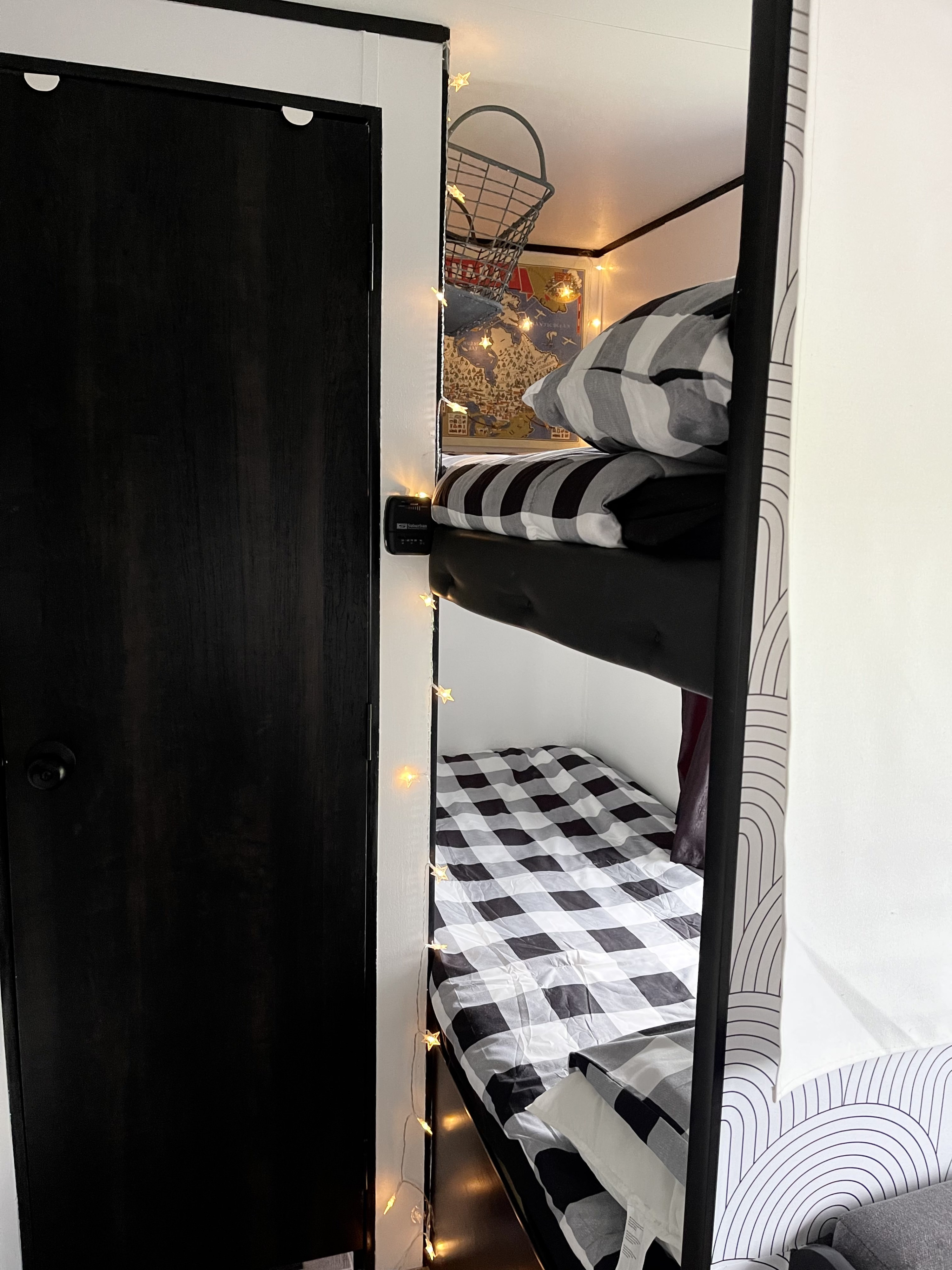 Cozy RV rental bunk beds feature black & white bedding, star lights, and a hanging basket for storage. Perfect for camper adventures.. Jayco Jay Flight SLX 2022