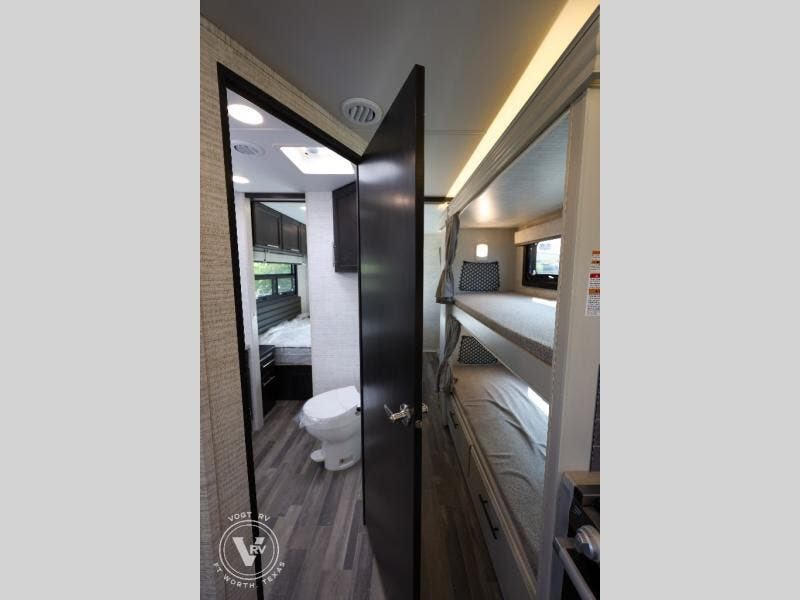 Inside this **rv rental**: a functional bathroom, a comfy bedroom, and space-saving bunk beds.. Jayco Greyhawk 31F 2024
