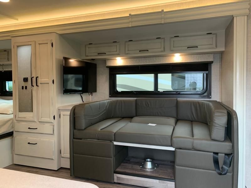 Spacious RV rental interior featuring a versatile convertible dinette, wall-mounted TV, and ample storage for comfortable travel.. Jayco Redhawk 2022